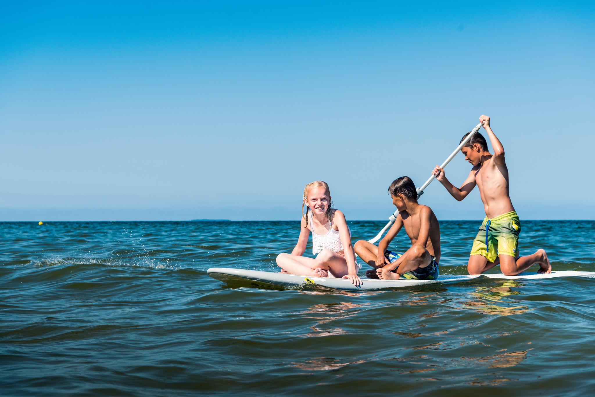 Kinder auf einem Board im Wasser