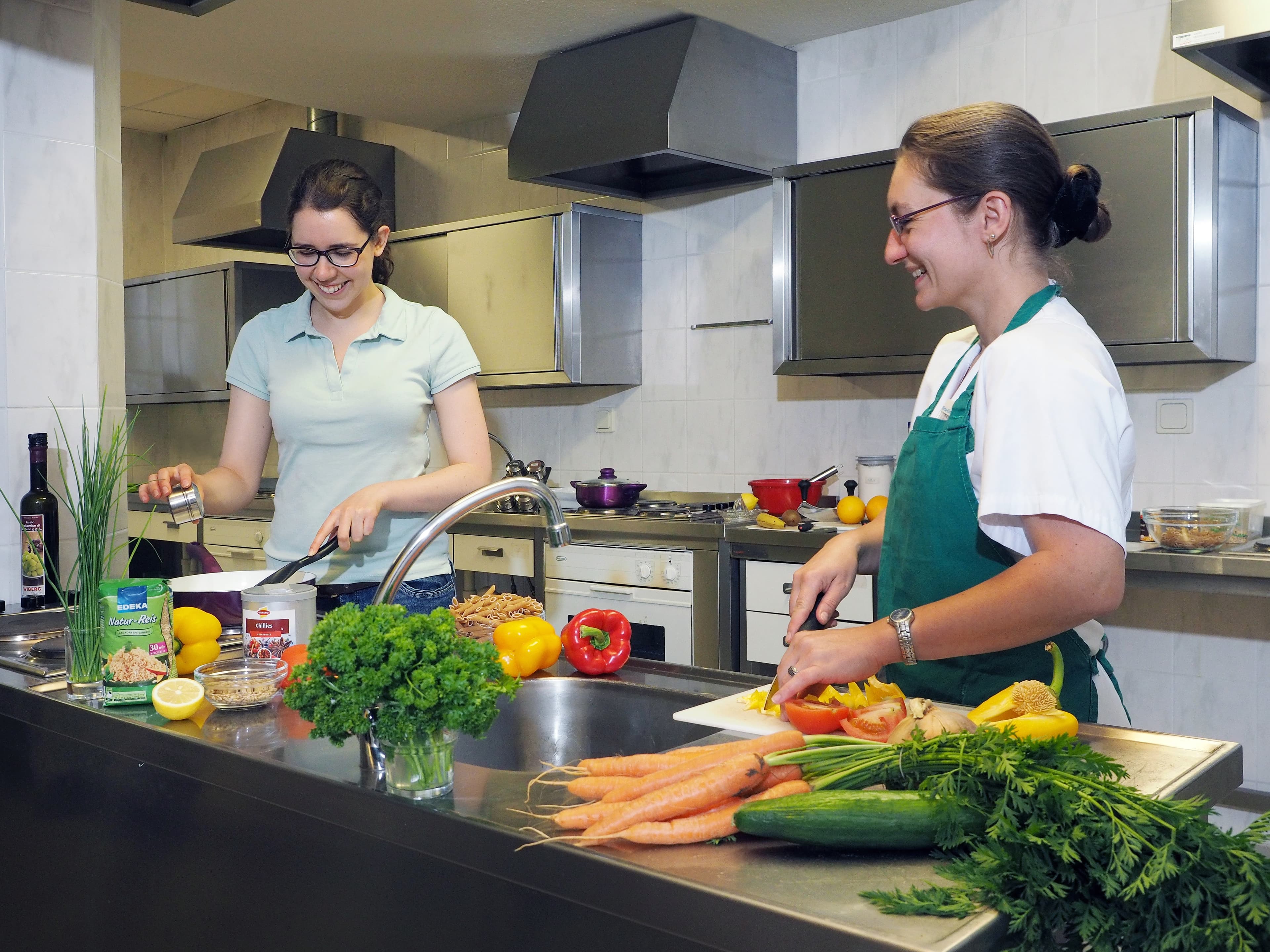 Zwei Personen kochen in einer Küche.