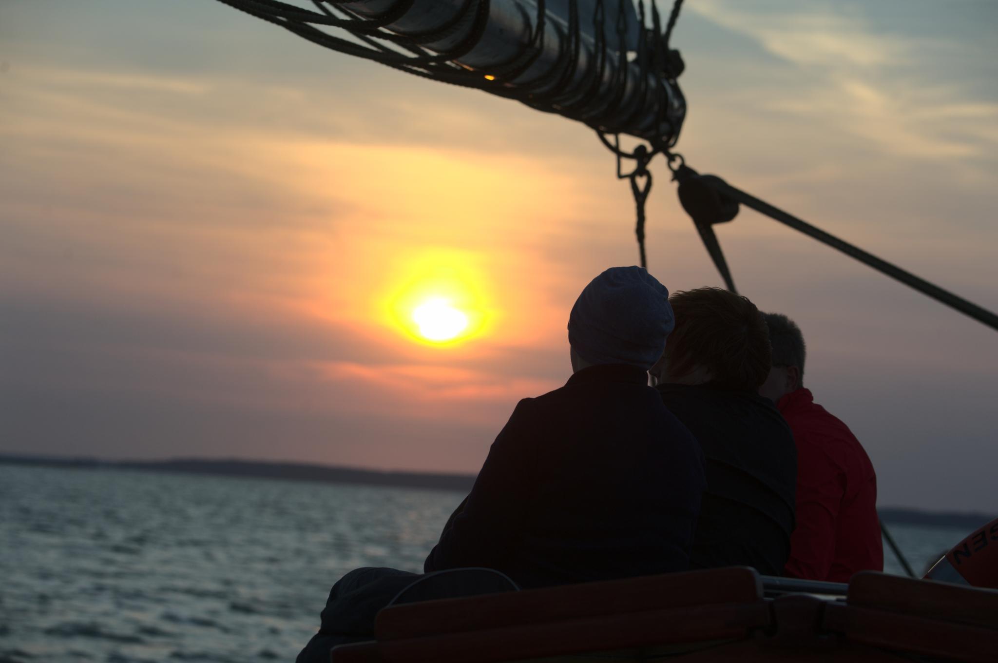 Pärchen beobachtet Sonnenuntergang auf einem Segelschiff