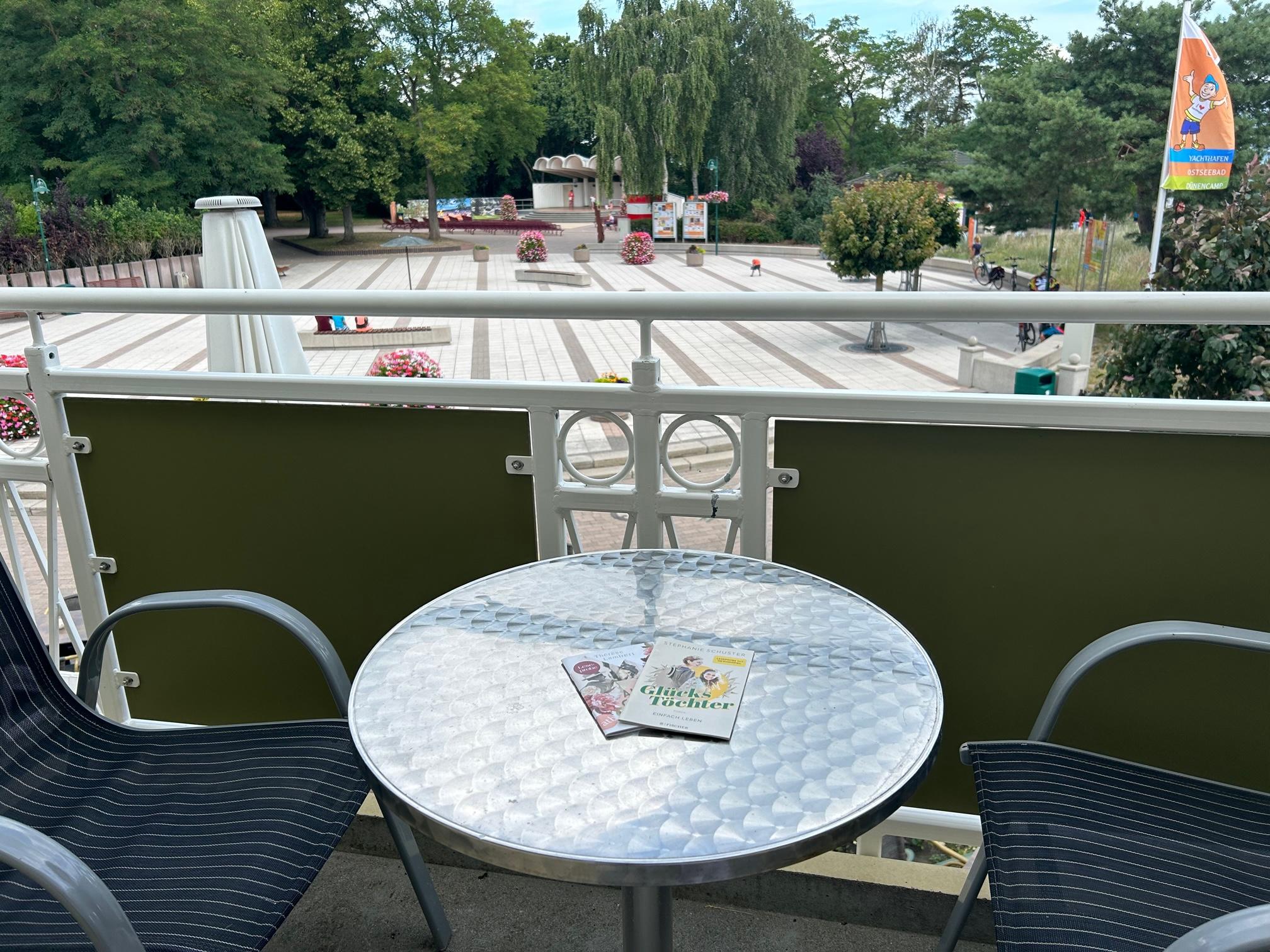 Balkon mit Tisch und Stühlen sowie Blick auf den Kurplatz