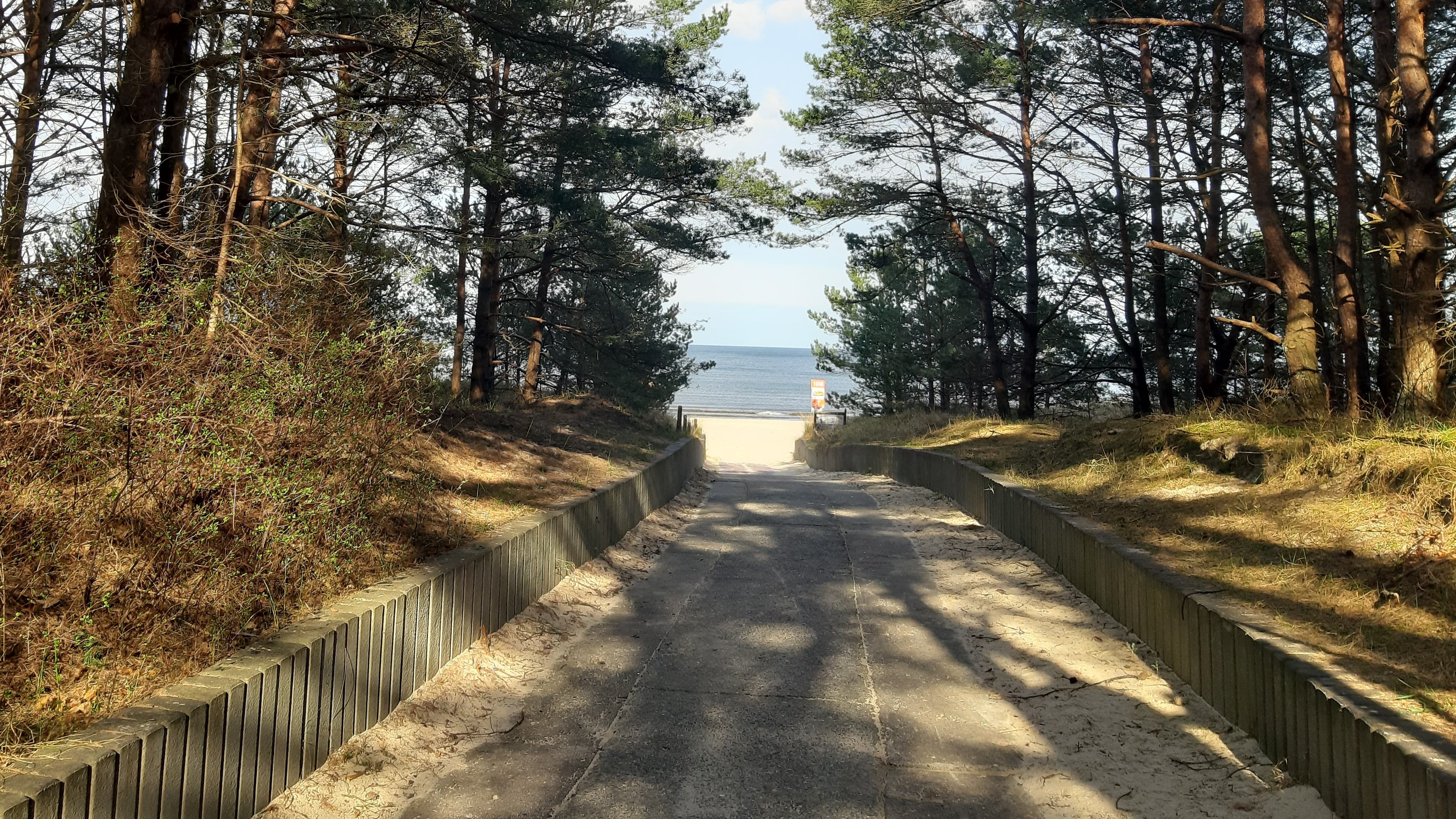 gepflasterter Weg bis zum Strand durch den Wald 