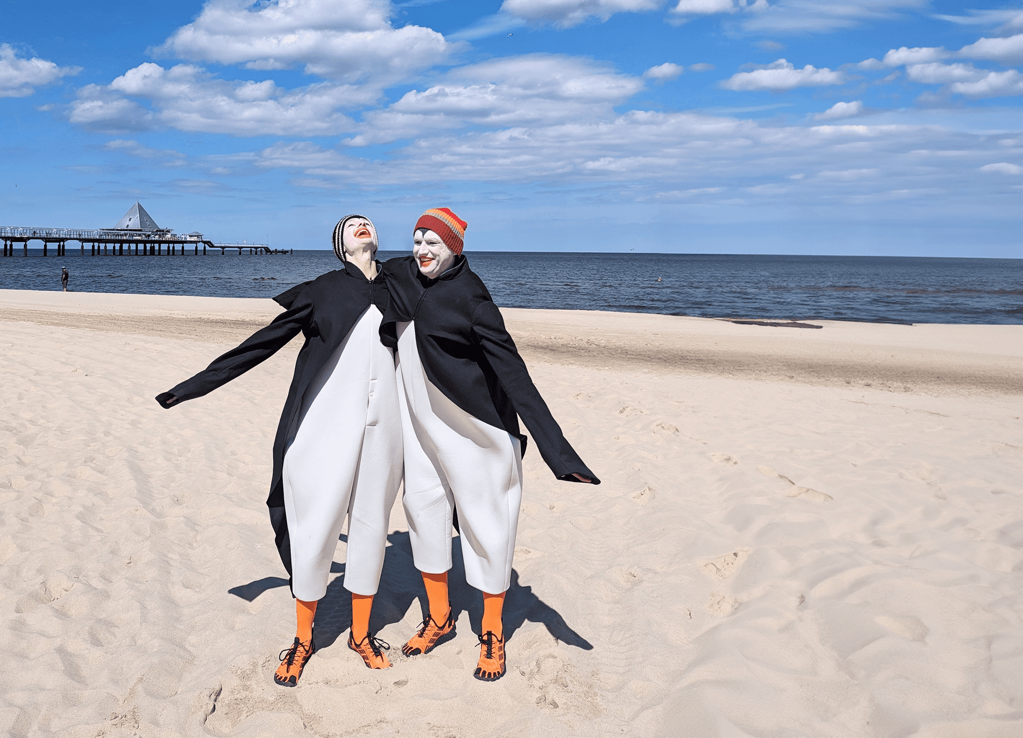 zwei als Pinguine verkleidete Schauspieler am Strand 