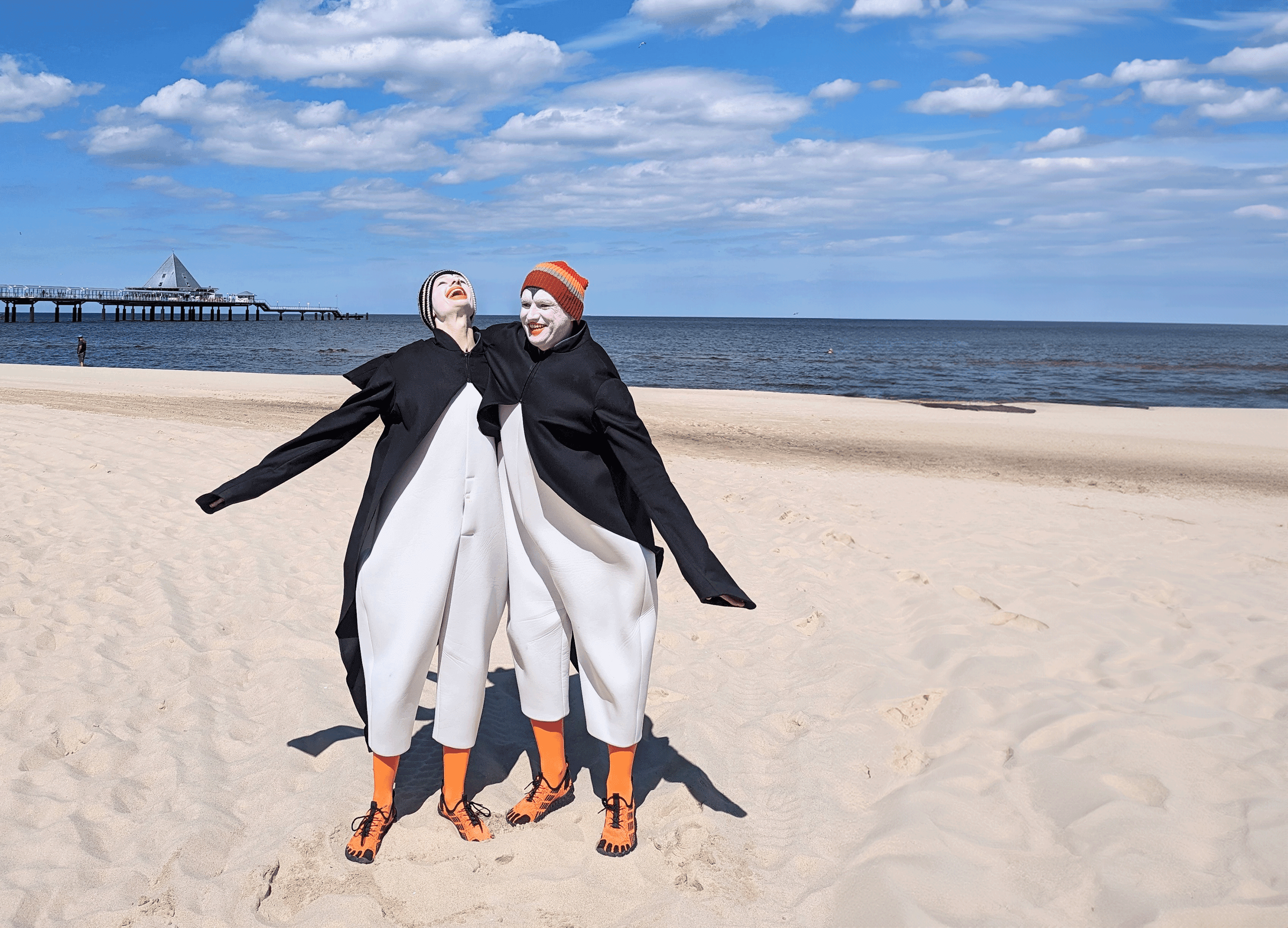 zwei als Pinguine verkleidete Schauspieler am Strand 