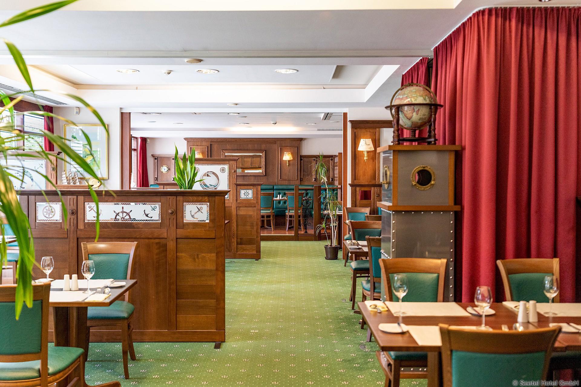 Innenraum eines Restaurants mit grünem Teppich und Holzmobiliar