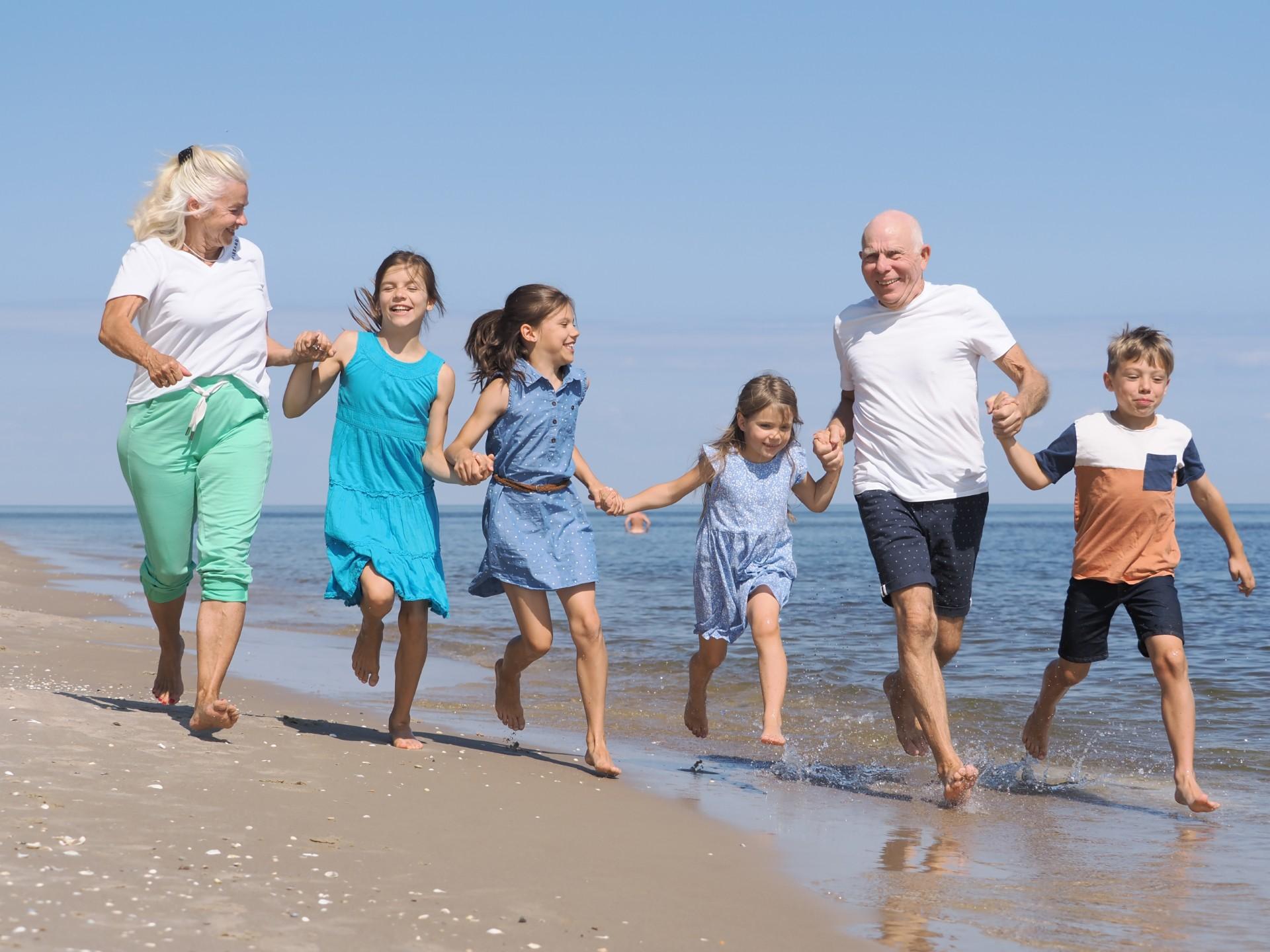 Oma und Opa mit  vier Kindern am Strand