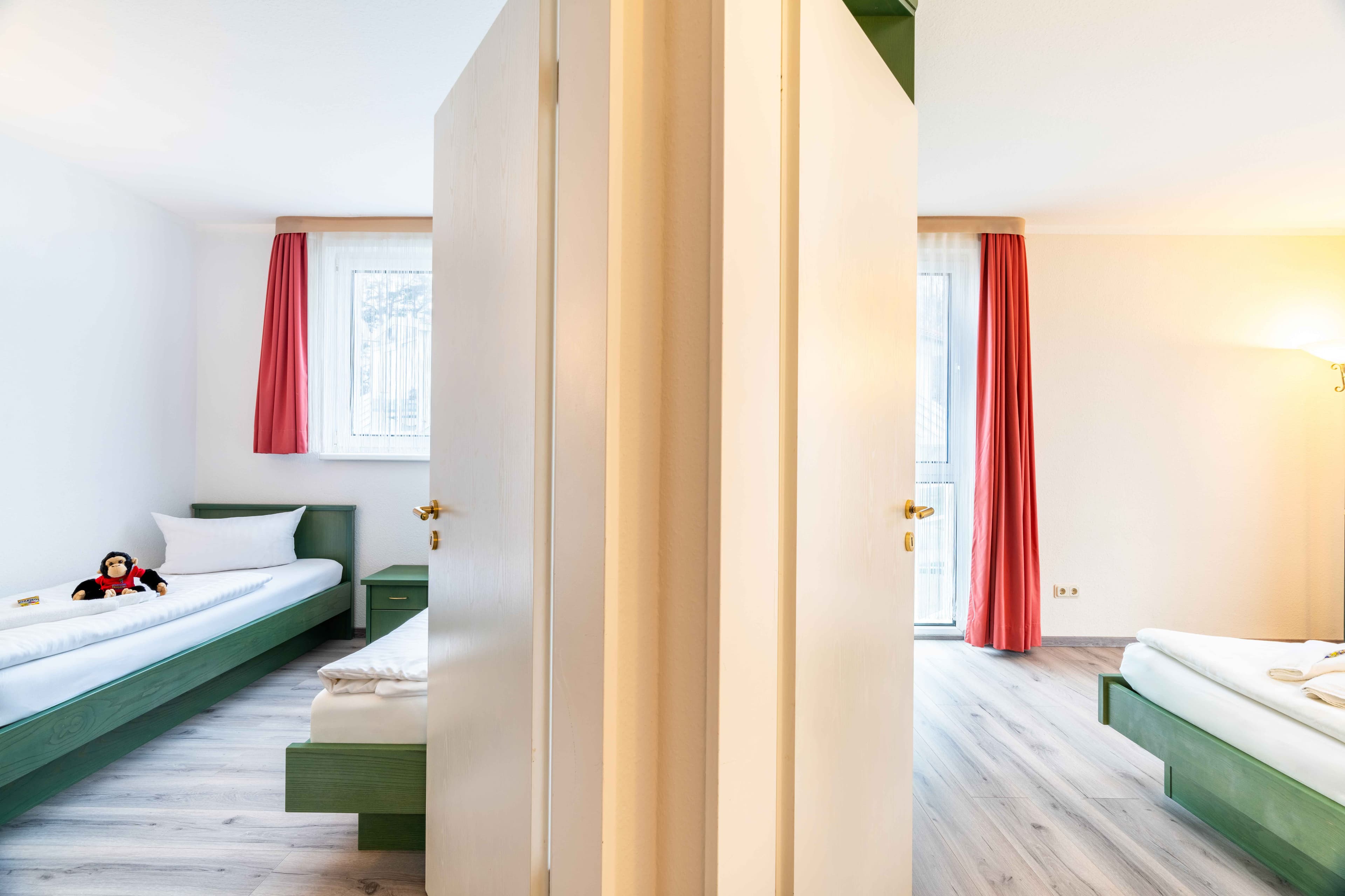 Ein Apartment mit zwei Schlafzimmern, eins für die Kinder mit niedlichen Plüschäffchen-Kuscheltieren, und eins für die Eltern nebenan