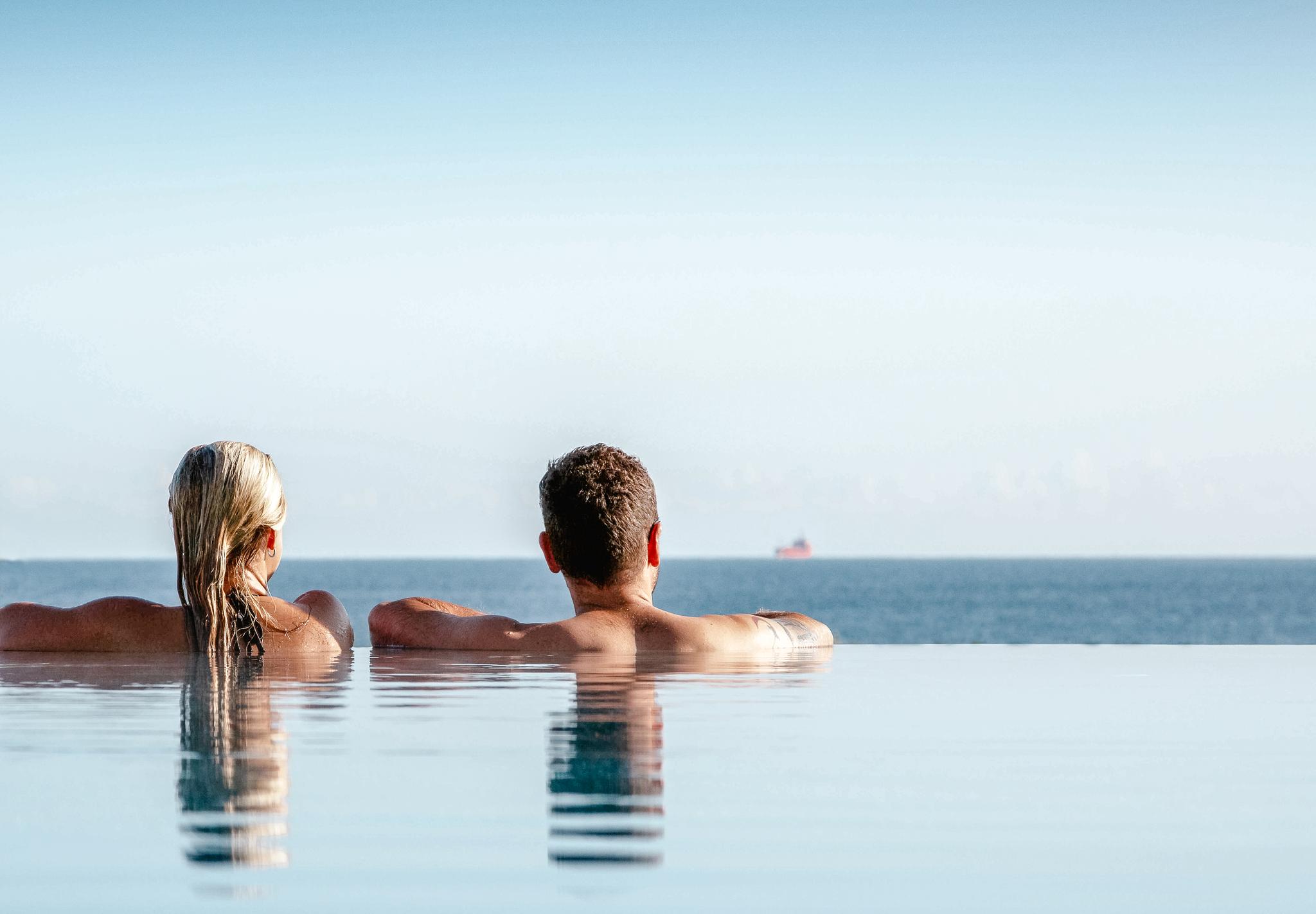 Paar im Pool mit Blick auf die Ostsee