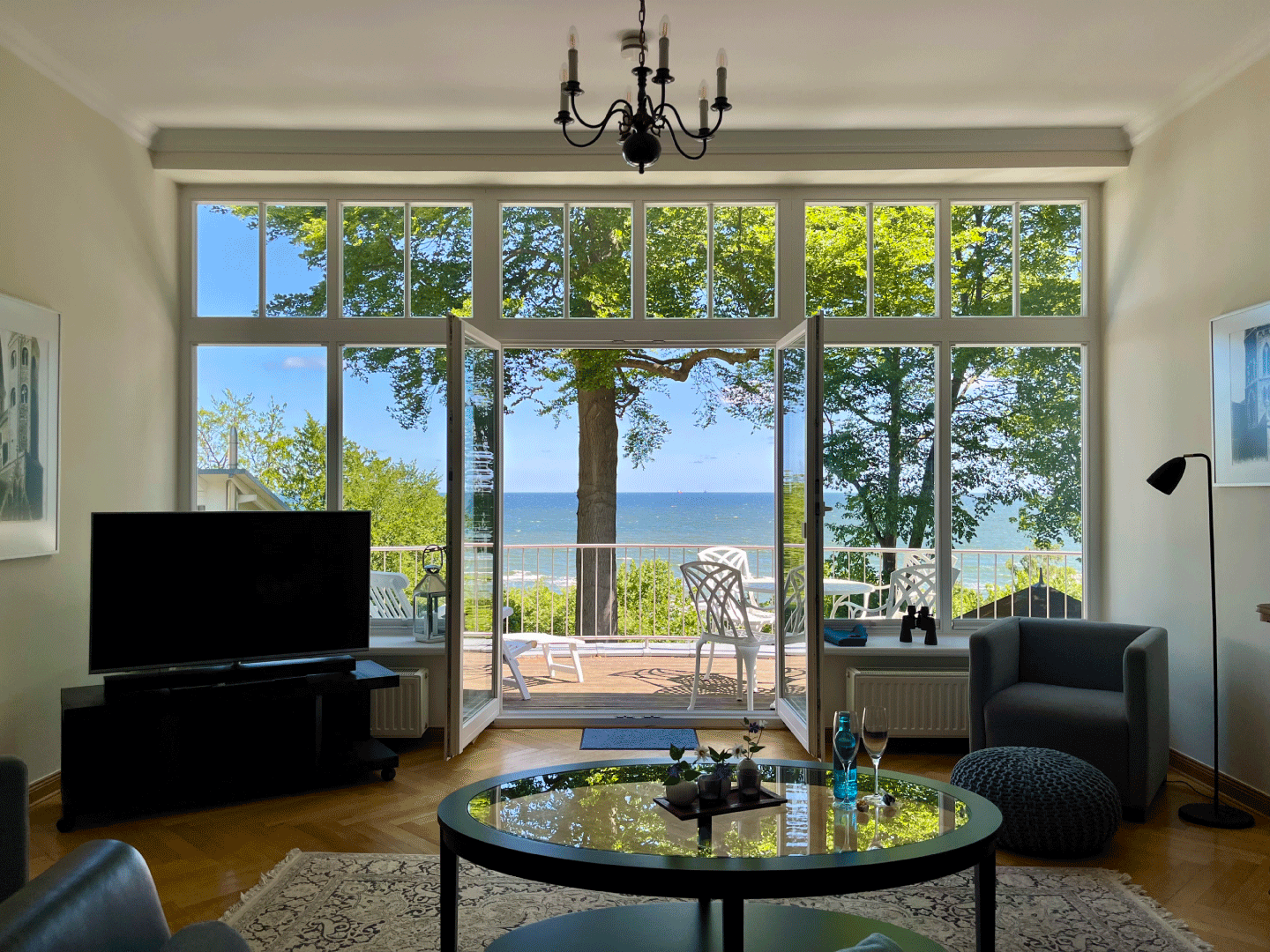 Ausblick aus dem Wohnzimmer der Villa Achterkerke auf eine grüne Wiese und das Meer dahinter