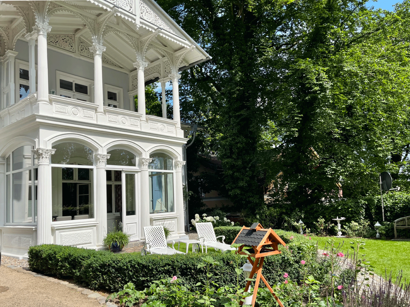 Frontansicht einer weißen Villa im Grünen