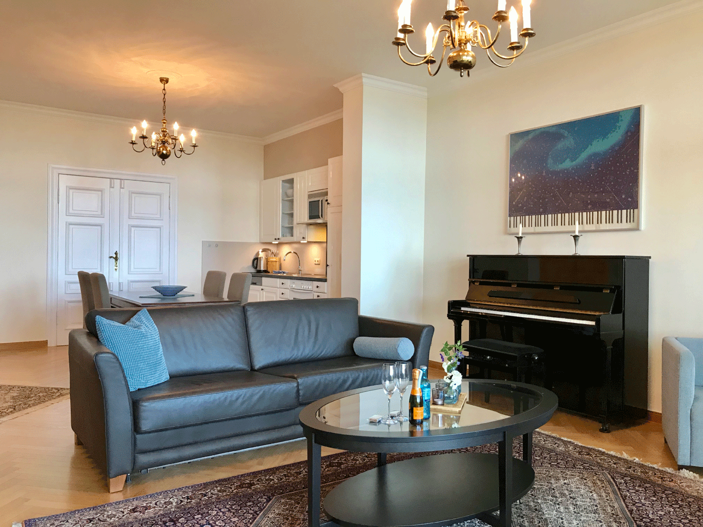 Wohnzimmer mit grauem Sofa und einem Klavier 