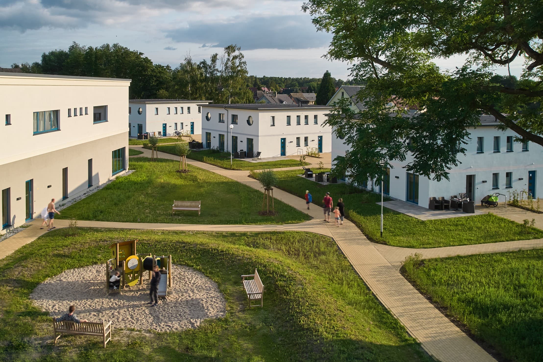 Außenansicht des Familienressorts Usedom, mit gepflegten, ausgeweiteten Grünflächen und weißen Häusern