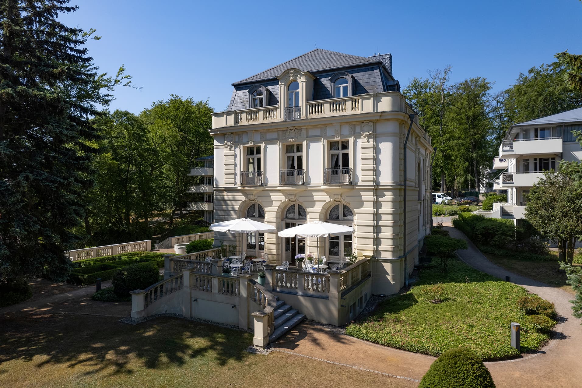 Schöne historisches Gebäude im Sonnenschein; Villa aus dem frühen 18. Jahrhundert; Bäderachrichtektur; drumherum ist ein schöner Garten