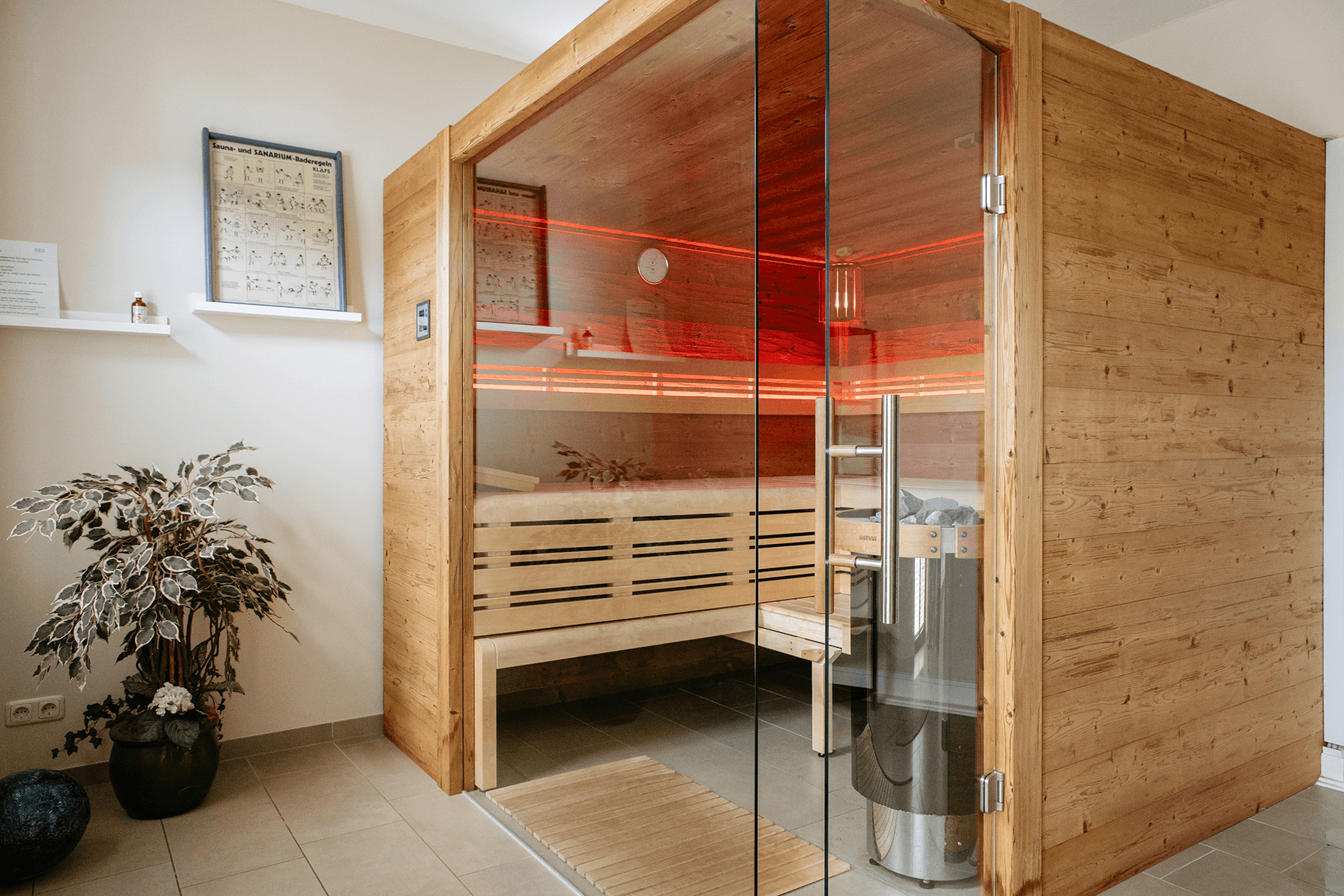 großzügige Holzsauna mit Glastür und rotem Licht
