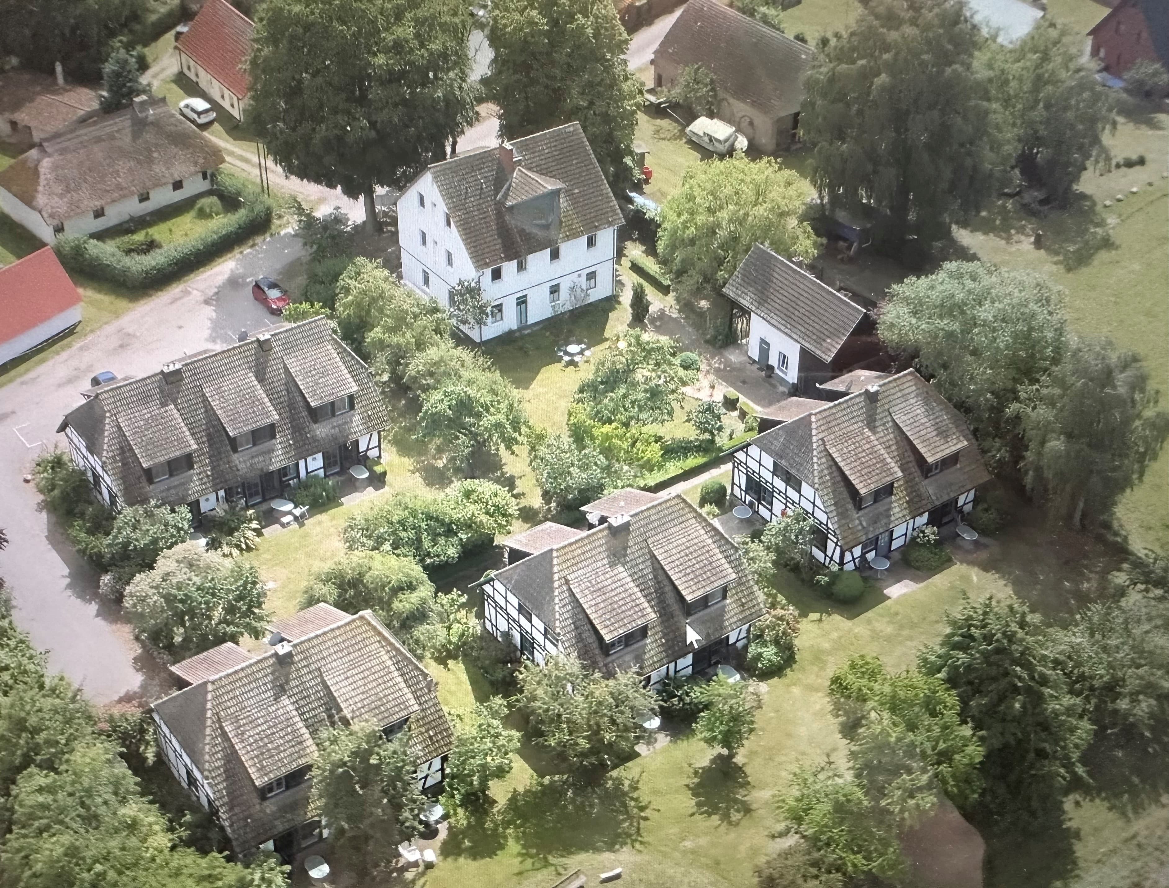 Die Ferienhausanlage aus der Vogelperspektive, viel grün in und um die Anlage