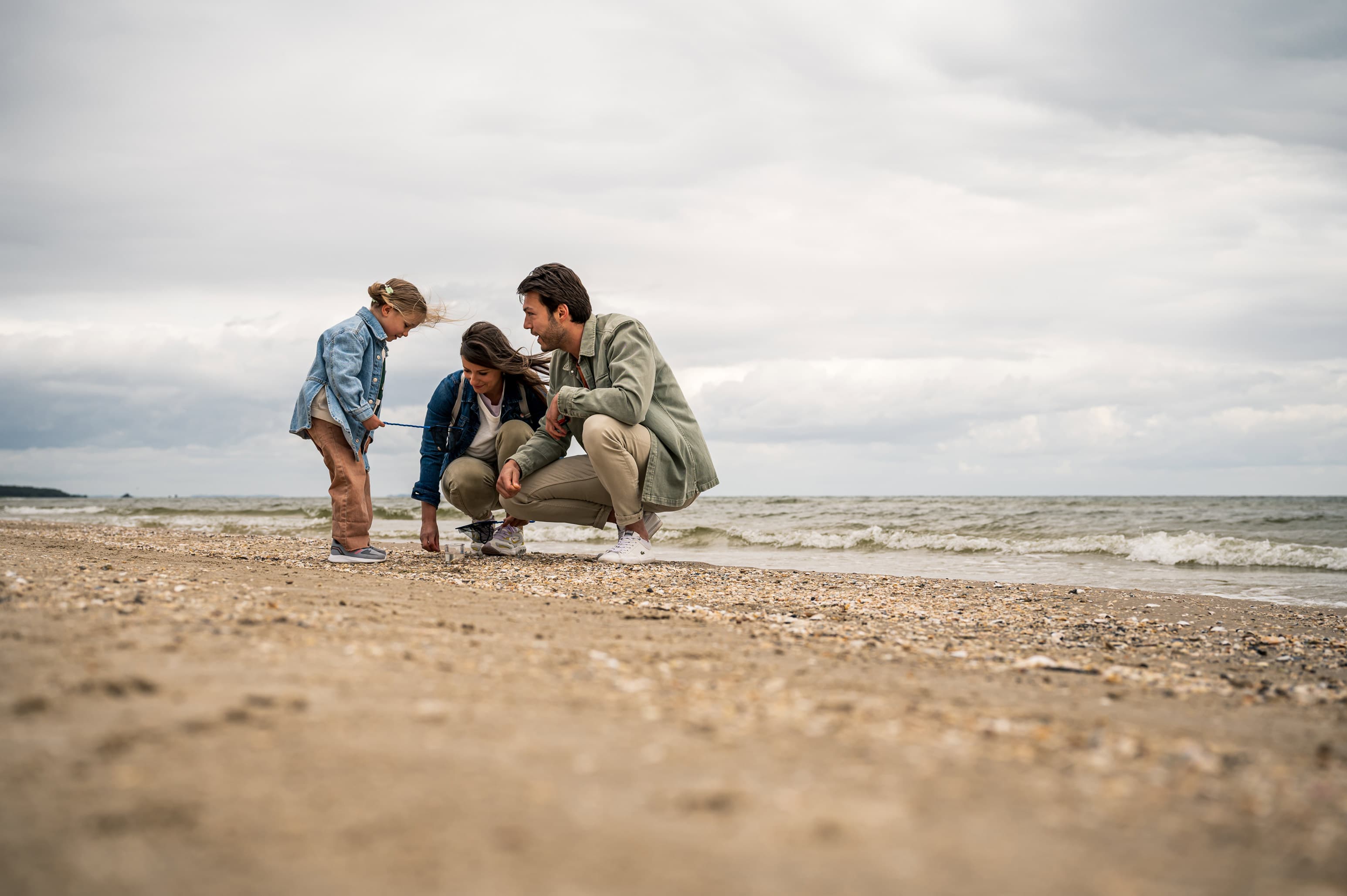 Familie am Strand beim Strandgut sammeln