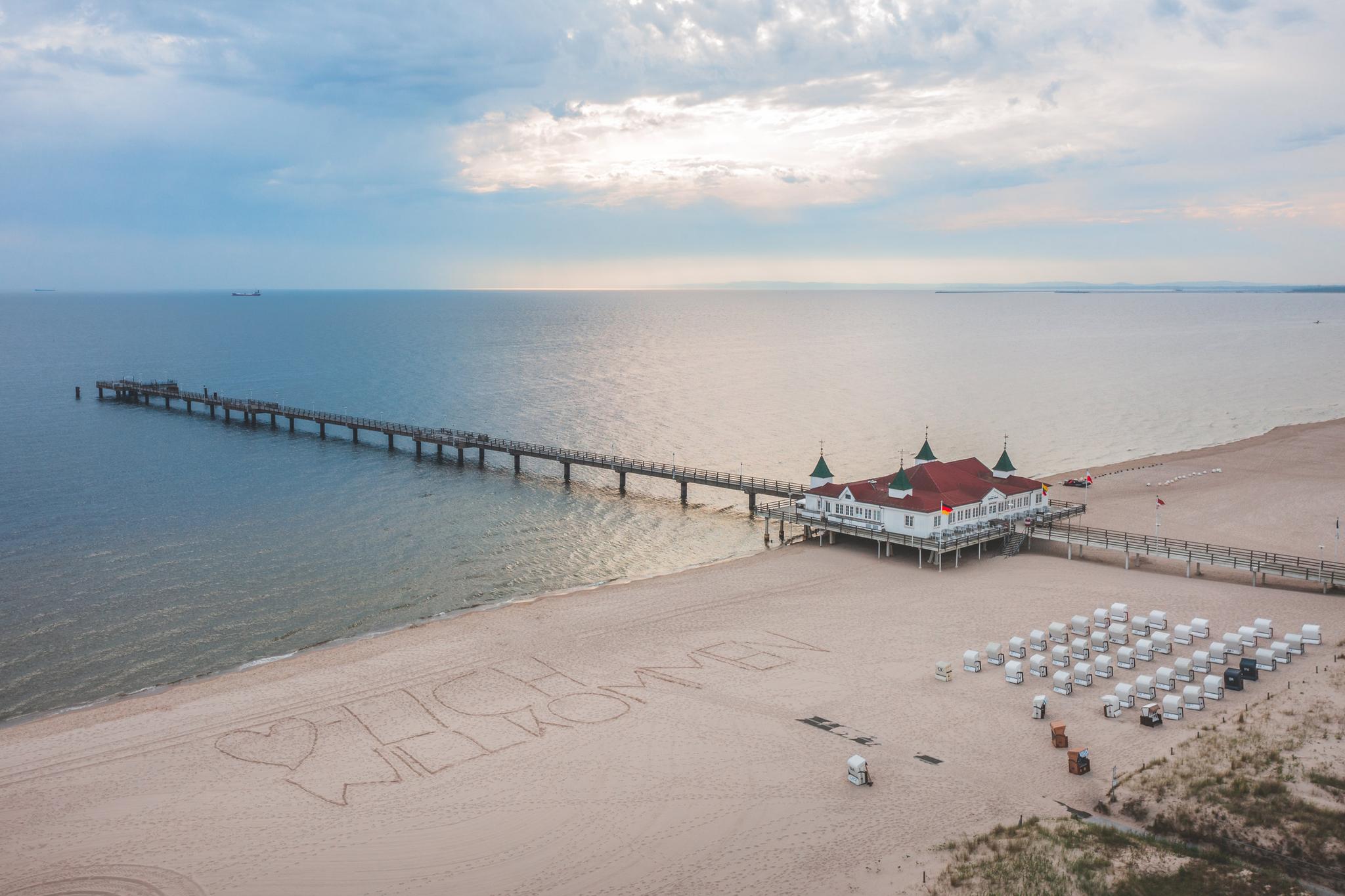 Luftbild Seebrücke Ahlbeck mit "Herzlich Willkommen"-Schriftzug am Strand