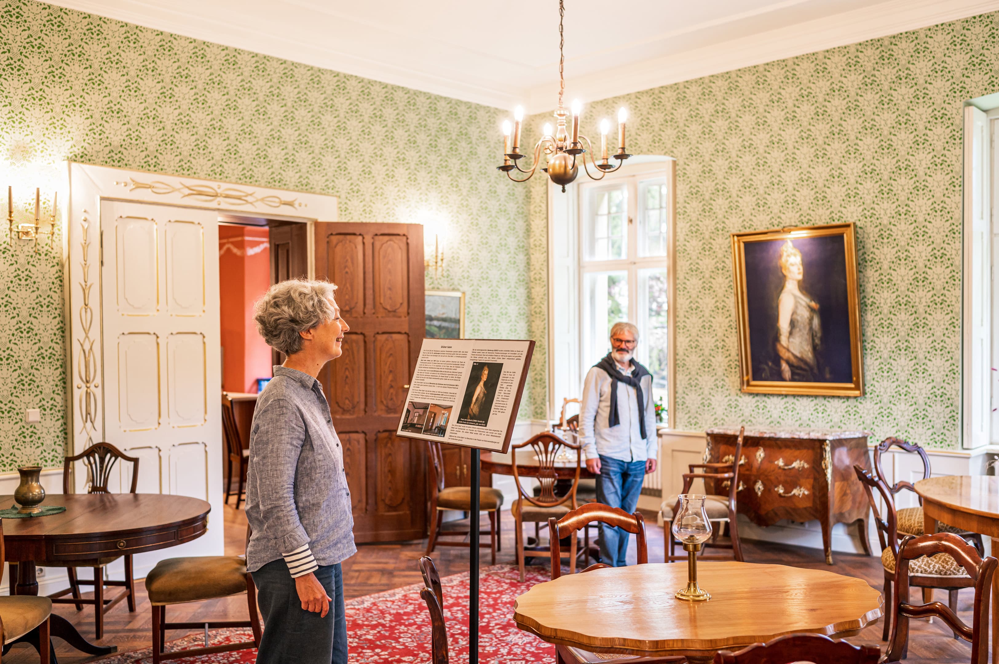 Zwei Personen besichtigen ein historisches Gemach vom Schloss Stolpe.
