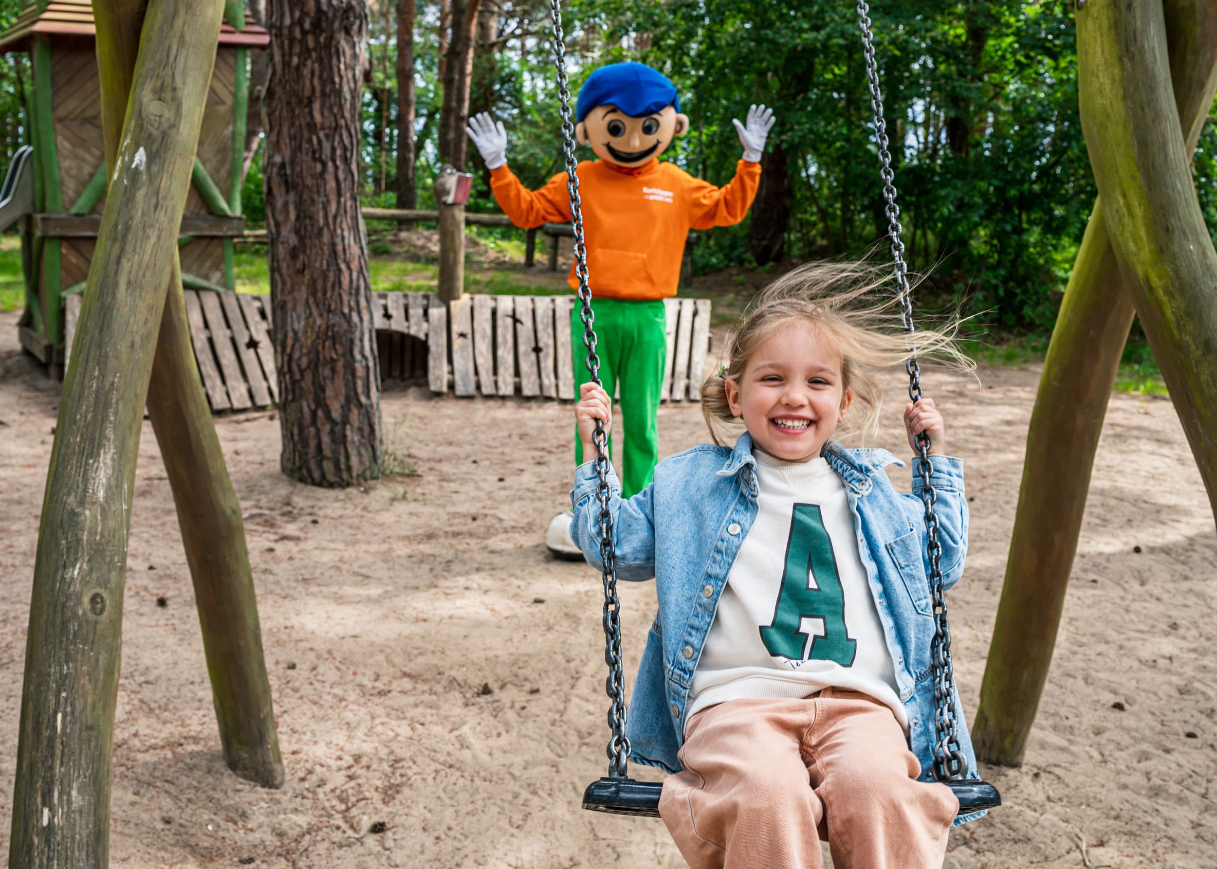Kind auf dem Spielplatz mit Maskottchen Karlchen aus dem Ostseebad Karlshagen