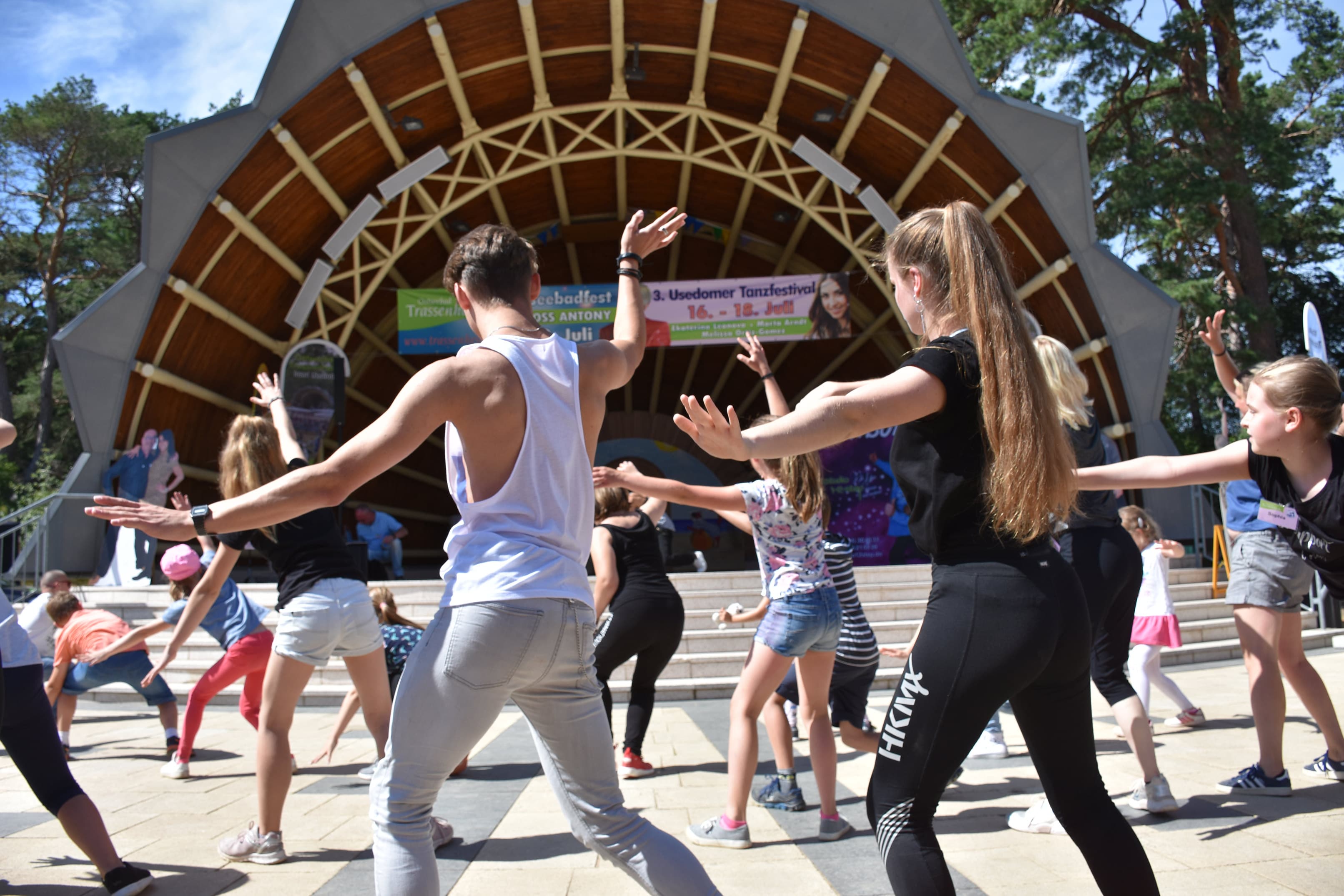 Menschen tanzen vor einer Bühne beim Tanzfestival in Trassenheide.