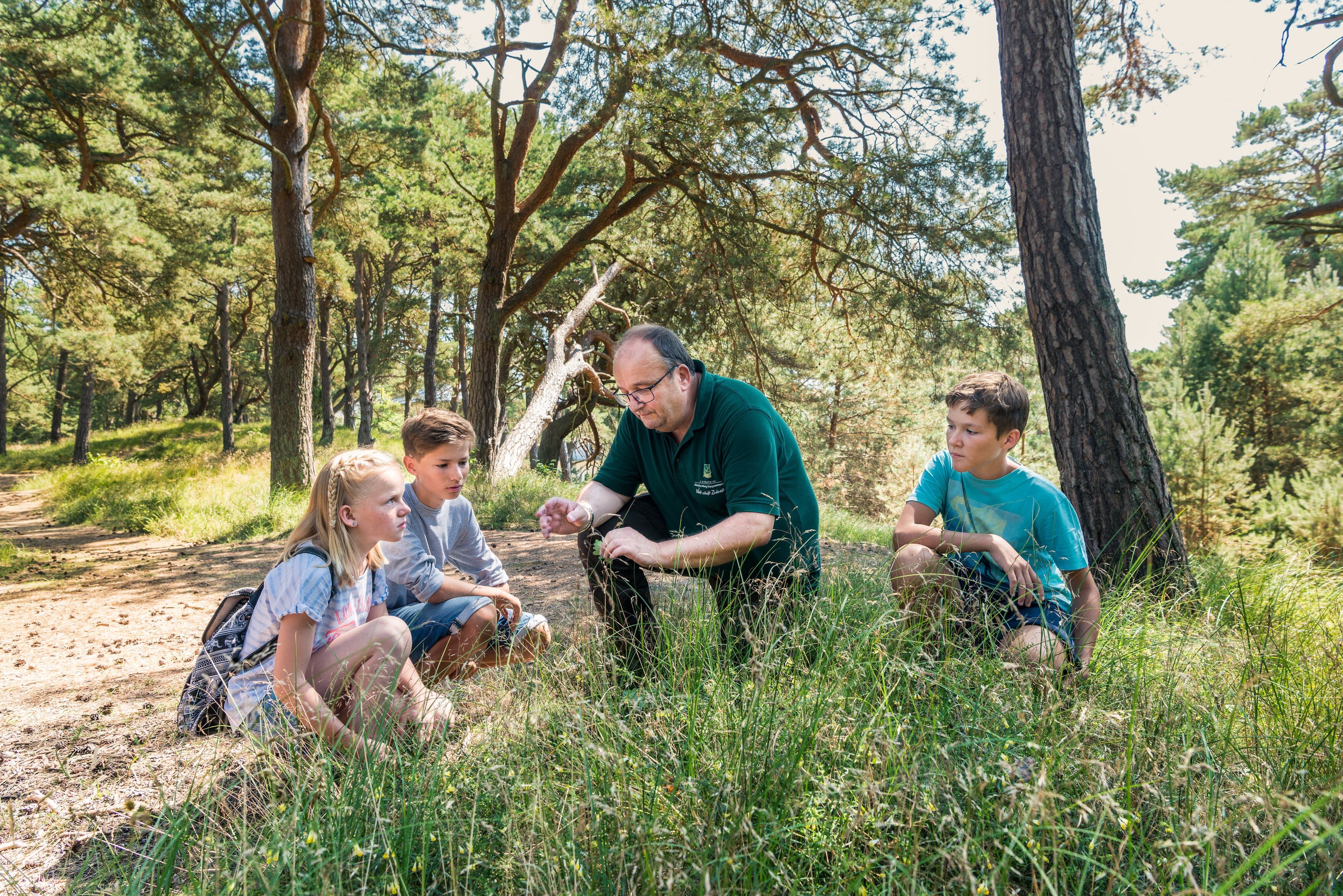 Kinder entdecken mit einem Naturführer den Küstenwald