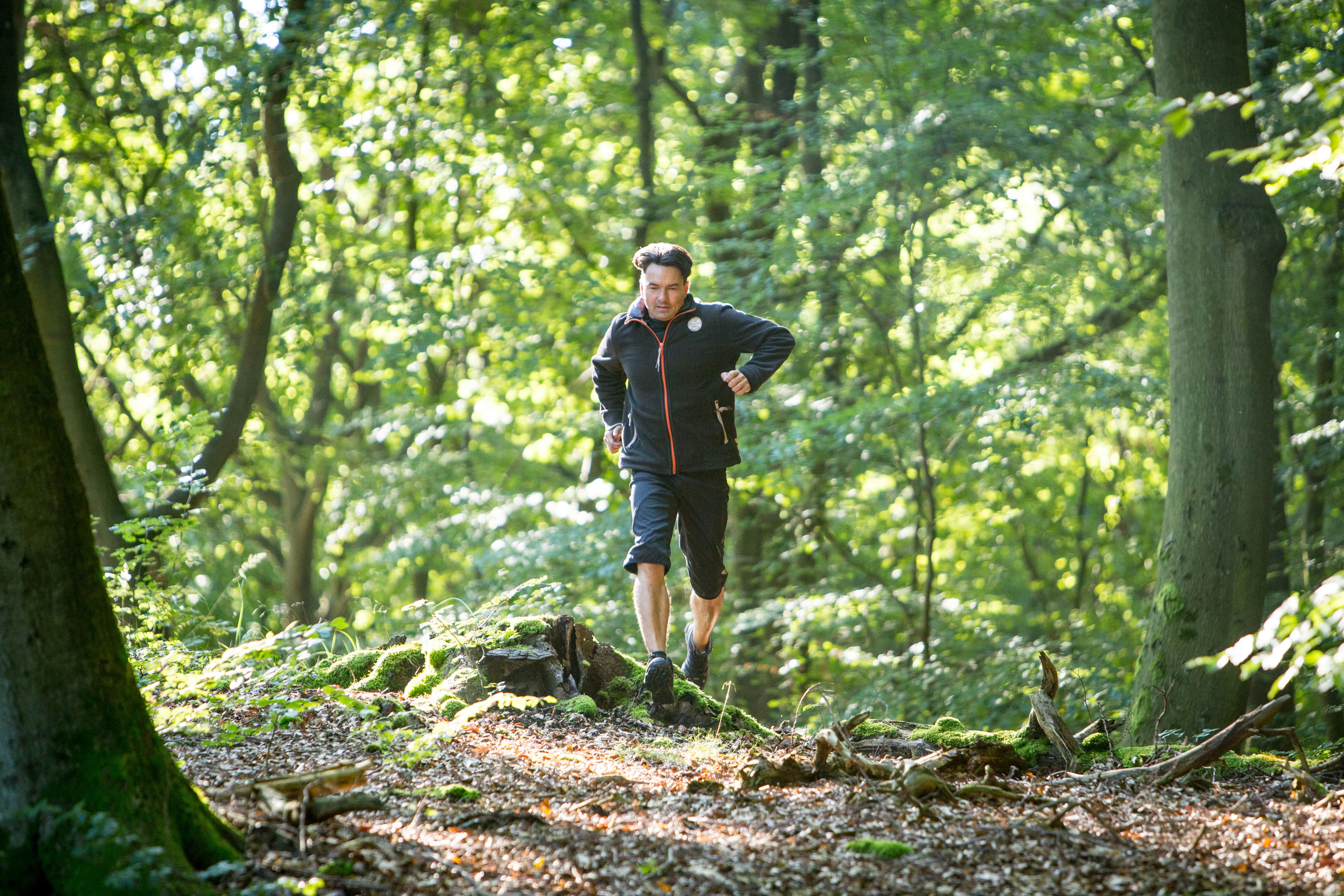 Mann läuft durch den Wald.