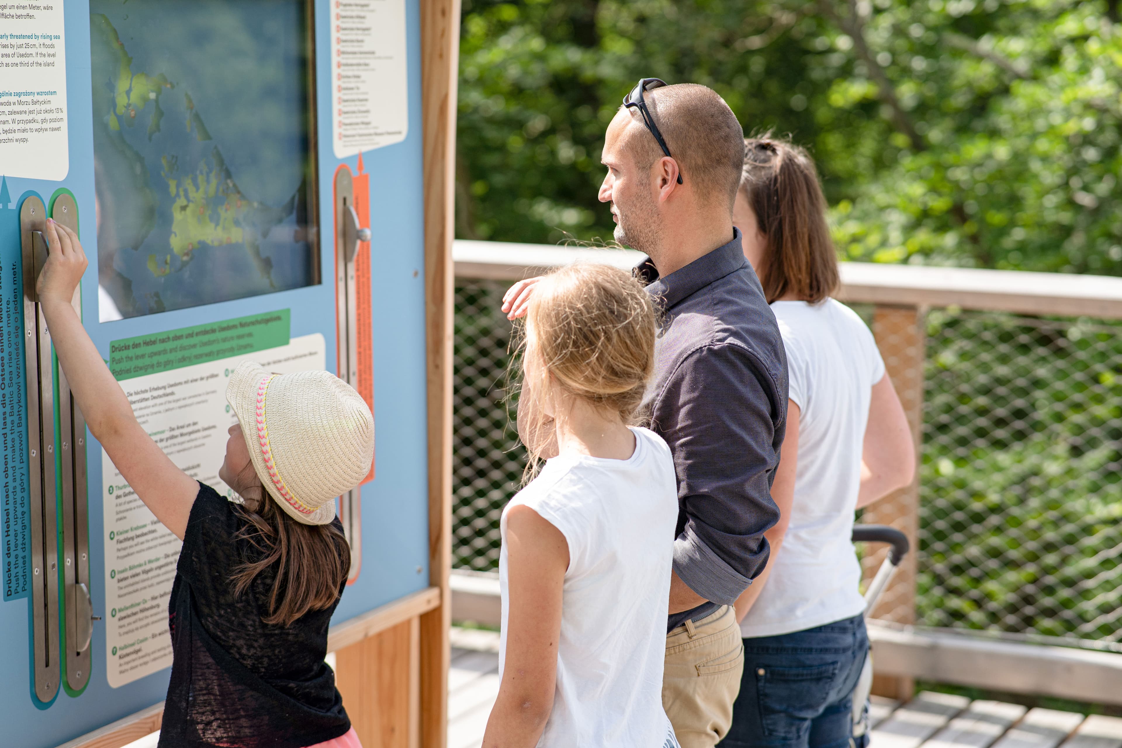 Familie an einer Lernstation auf dem Baumwipfelpfad
