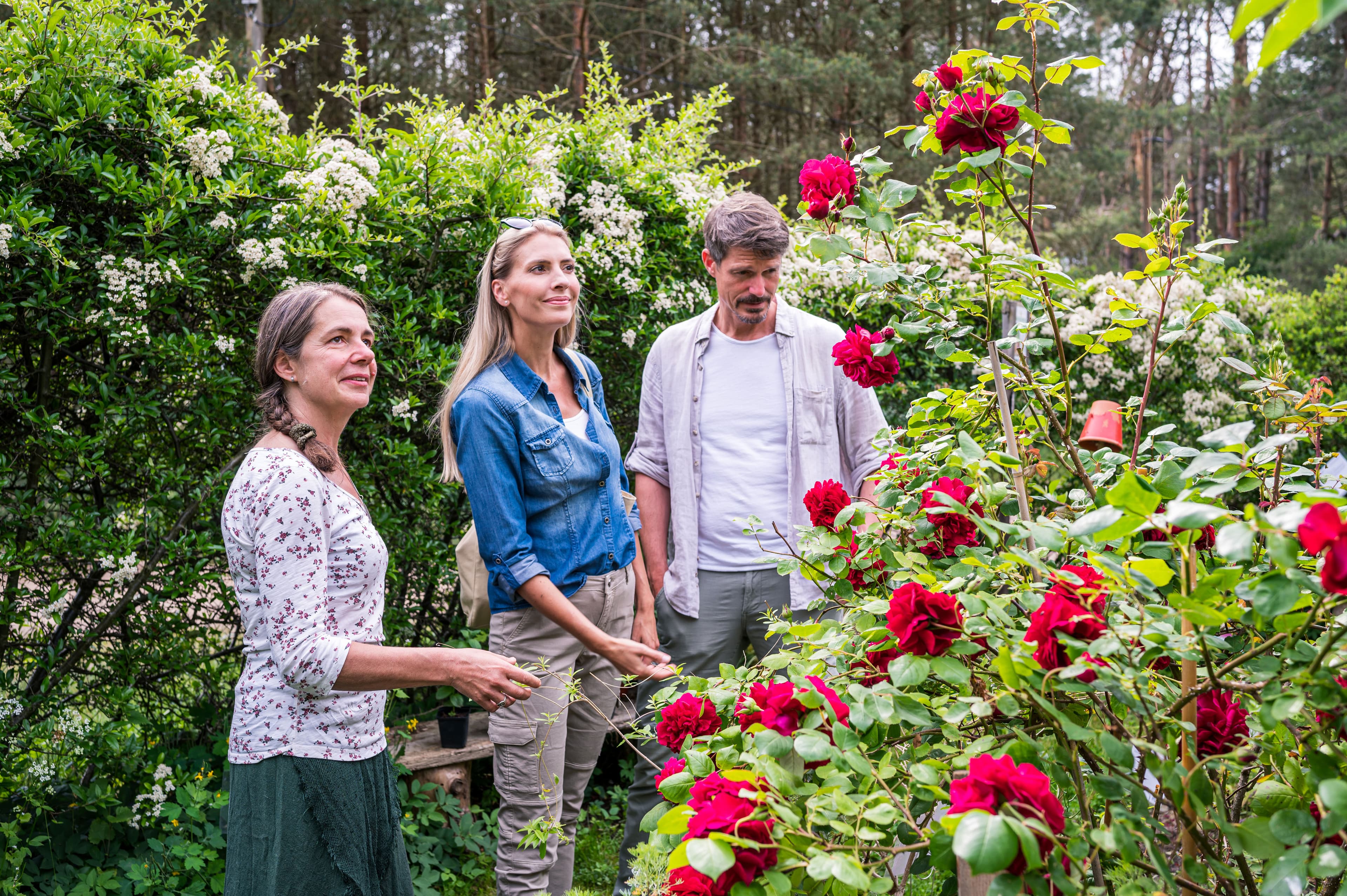 Drei Personen in einem blühenden Garten