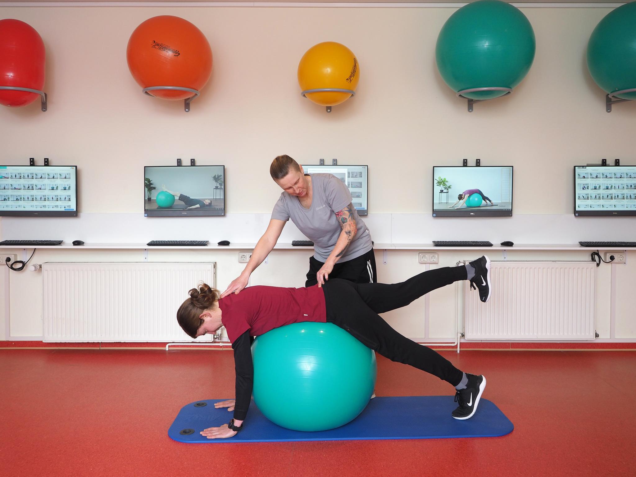Zwei Personen beim Training mit einem Gymnastikball