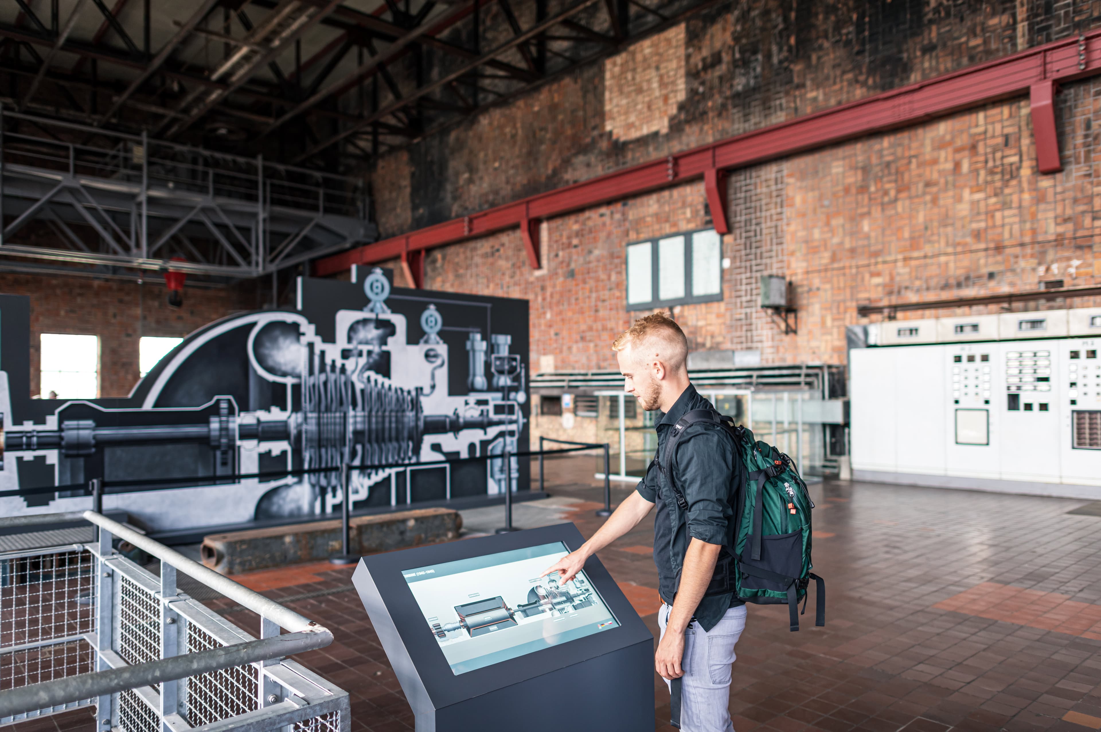 Mann bedient einen Infoscreen im Historisch-Technischen Museum Peenemünde.
