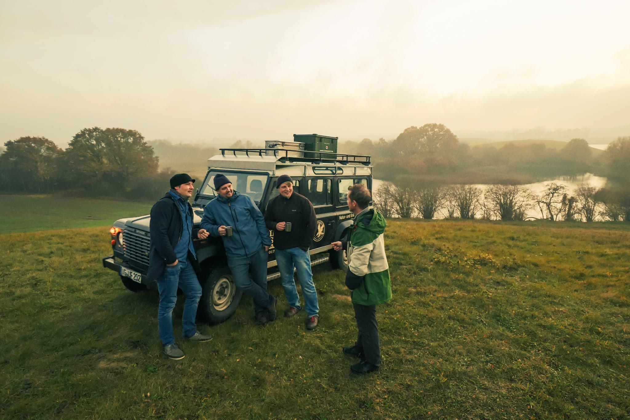 Team der Insel-Safari steht vor Land Rover