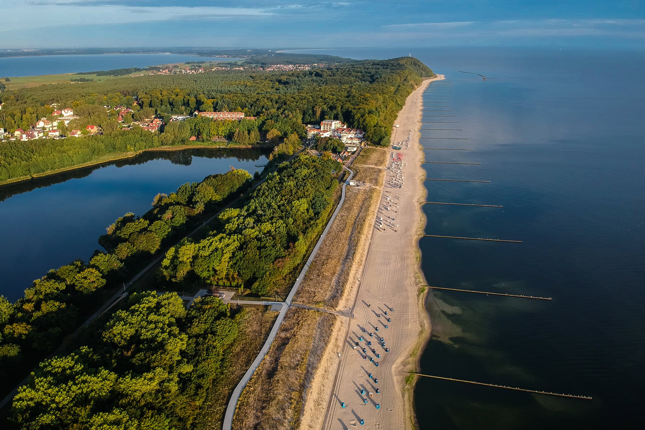 Luftaufnahme vom Seebad Loddin mit Strand, Kölpinsee und weiten Küstenwäldern.