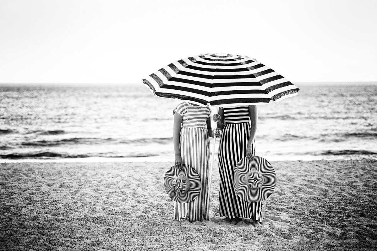 Schwarz-Weiß-Fotografie von zwei Personen am Strand