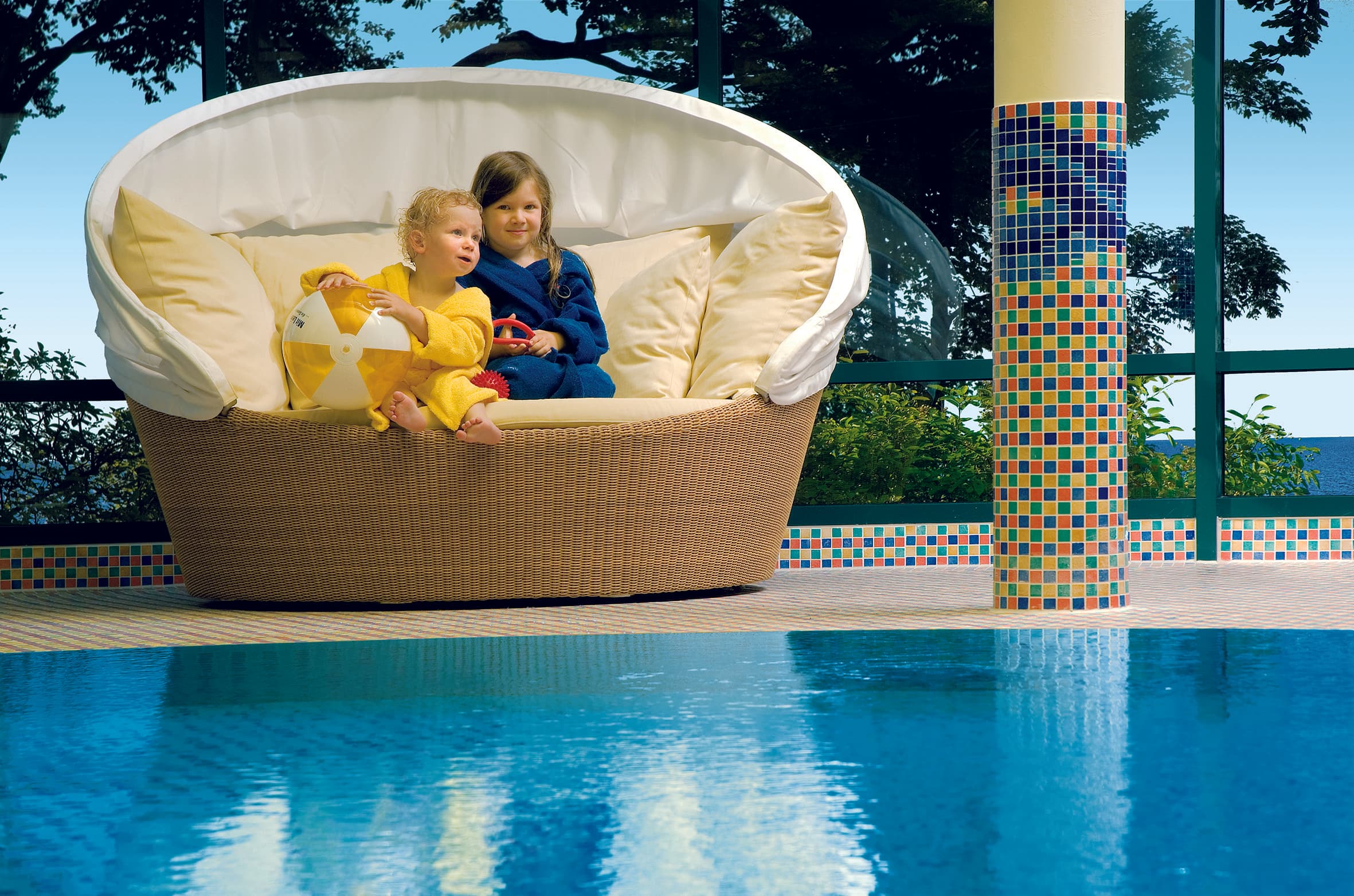 Kinder sitzen am Pool