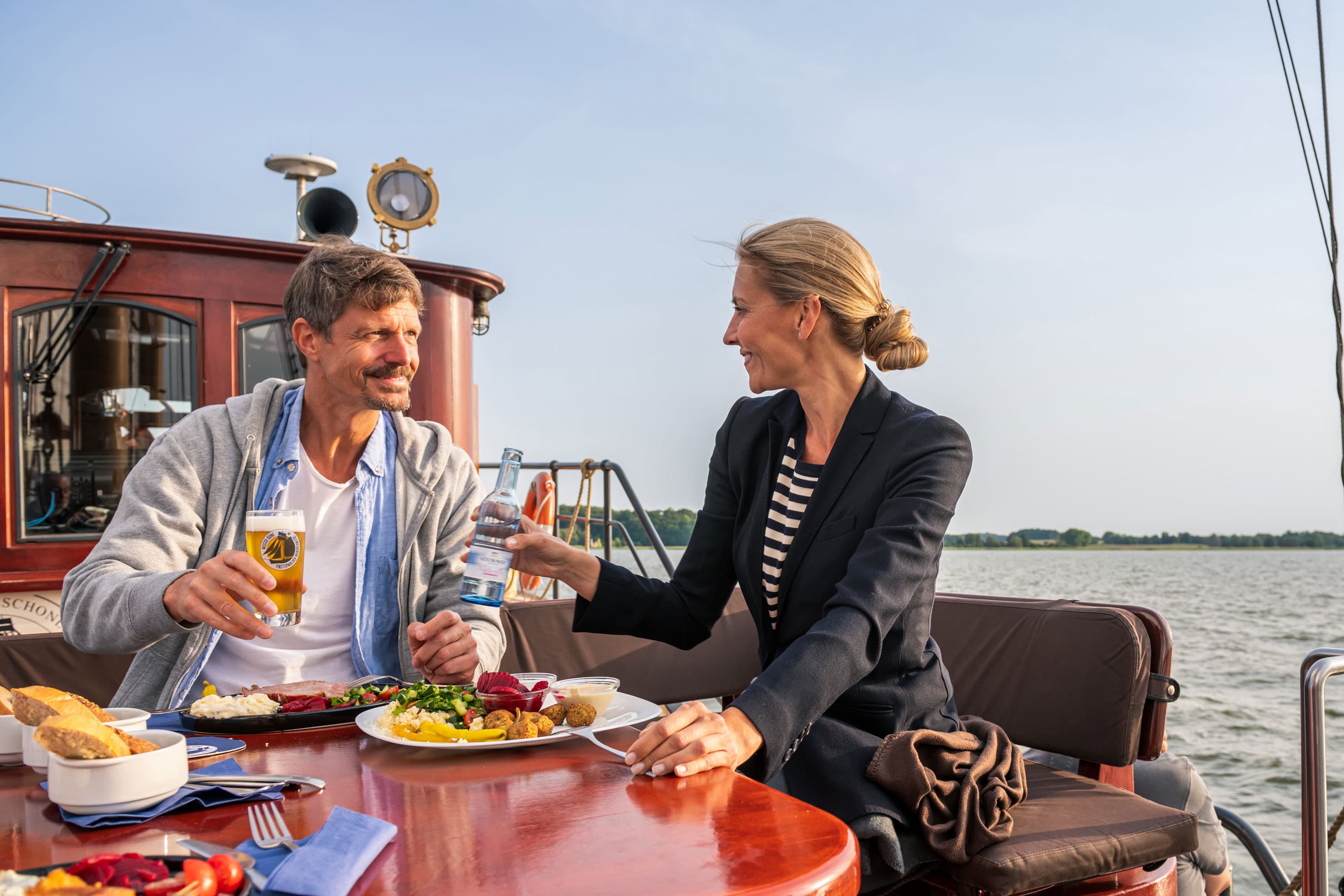 Pärchen an einem gedeckten Tisch auf einem Segelschiff