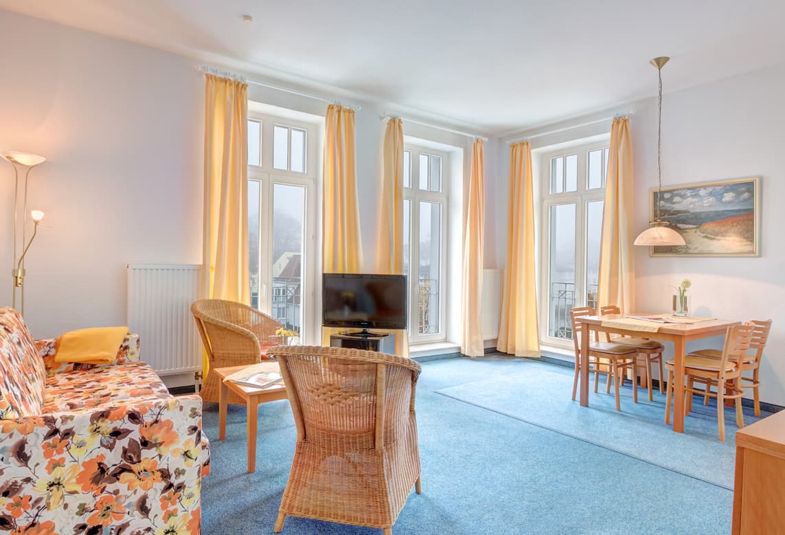 Wohnbereich mit Sofa, Tisch, Stühlen und TV