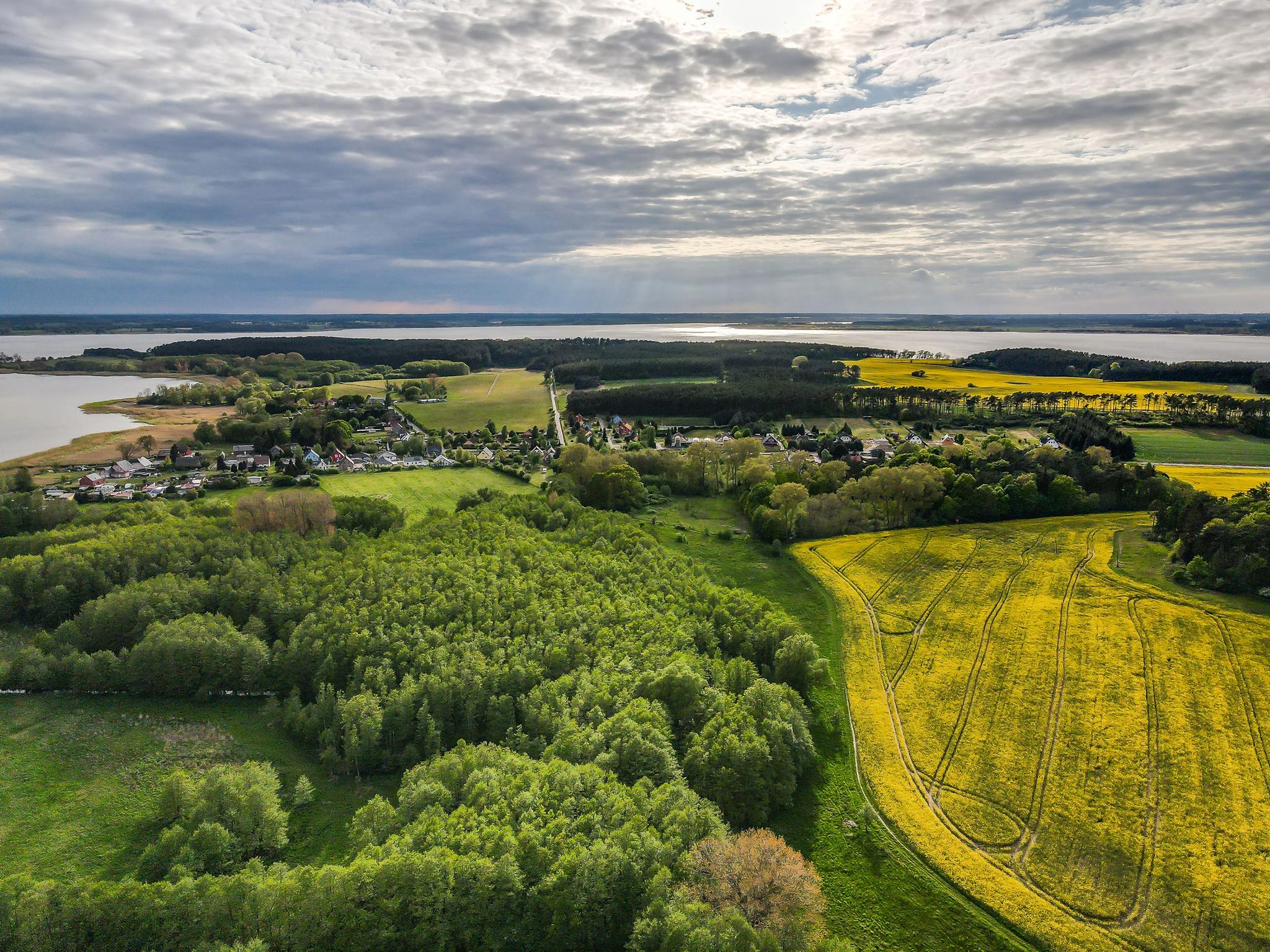 Das Bild zeigt eine Luftaufnahme der Halbinsel Gnitz mit viel weiter Natur und dem Blick auf das Achterwasser.