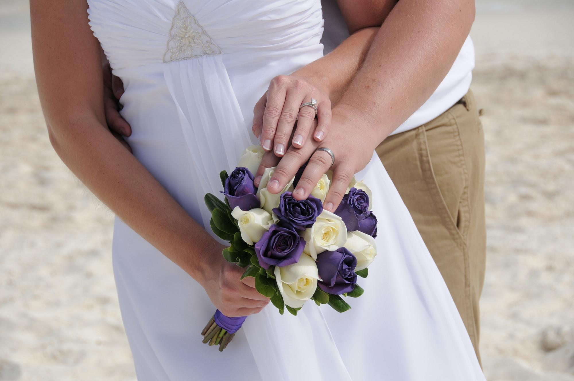 Brautpaar mit Blumenstrauß am Strand