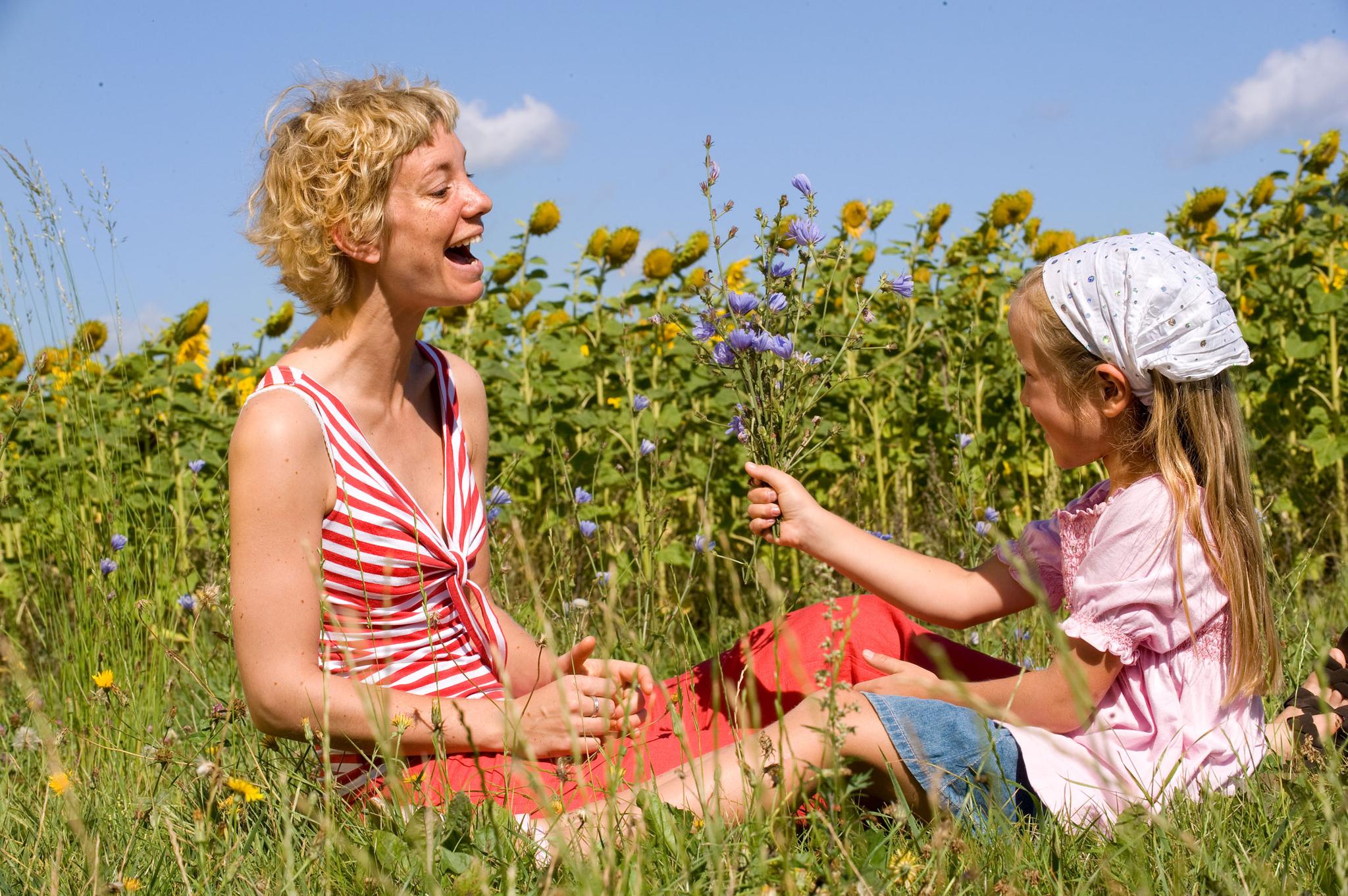 Frau mit Kind an einem Sonnenblumenfeld
