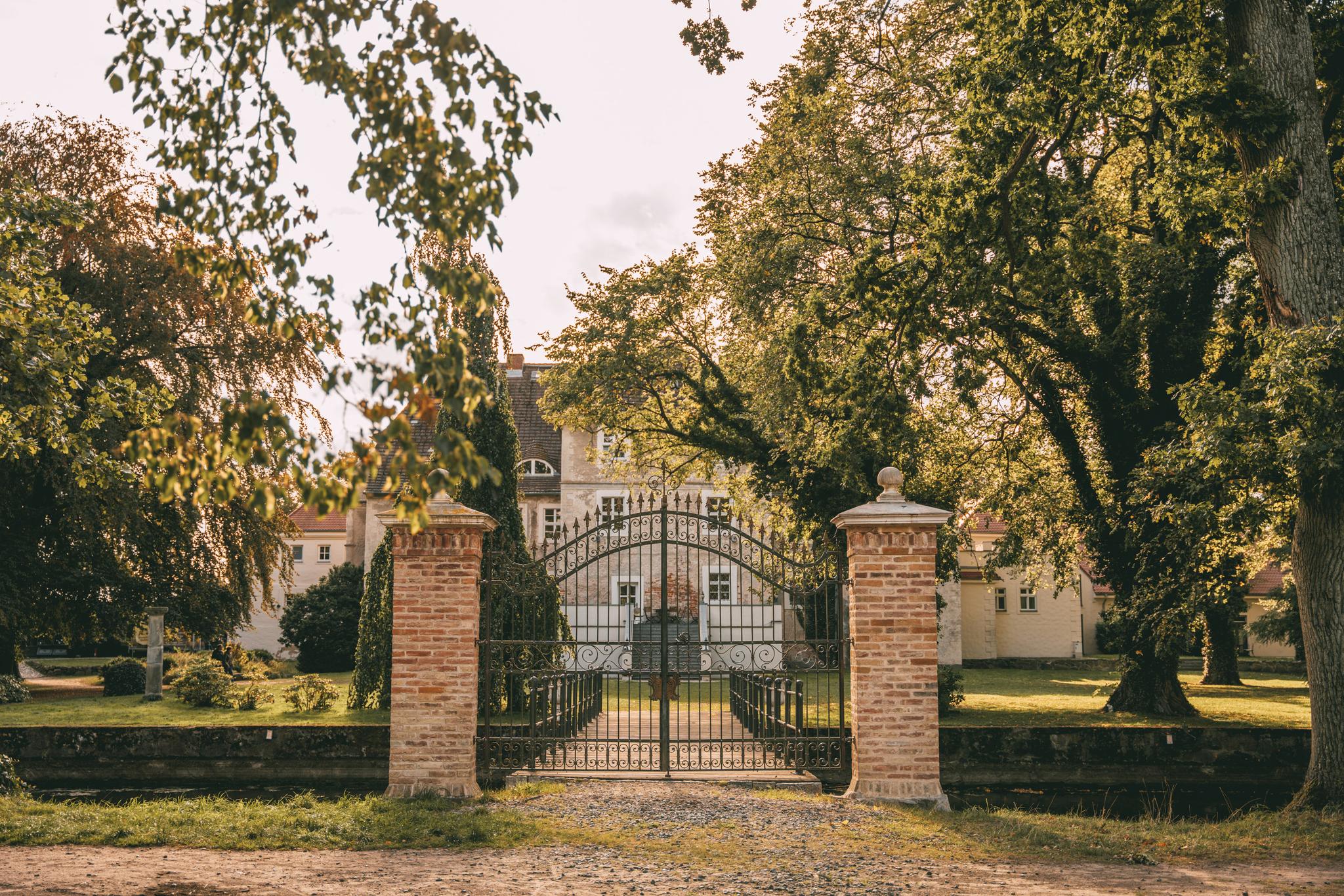 Das Bild zeigt das Tor mit Eingang zum Garten auf der Rückseite des Wasserschloss Mellenthin. 