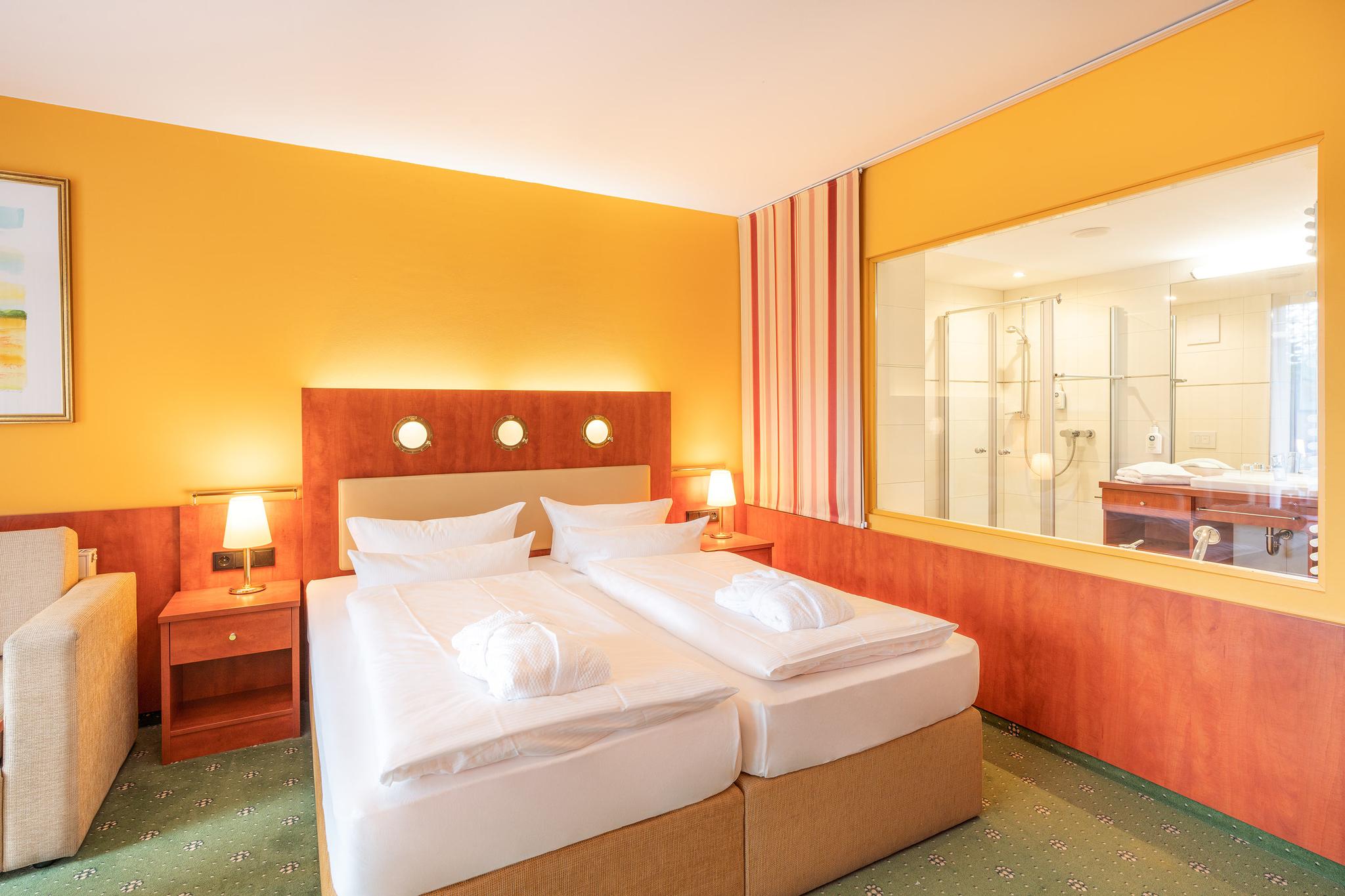 Nautic Hotel Zimmer mit Doppelbett und orange Wandfarben