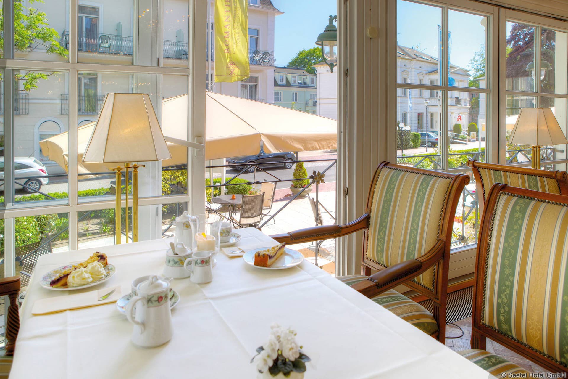 Tisch in einem Restaurant mit Kuchengedeck und zwei Stühlen