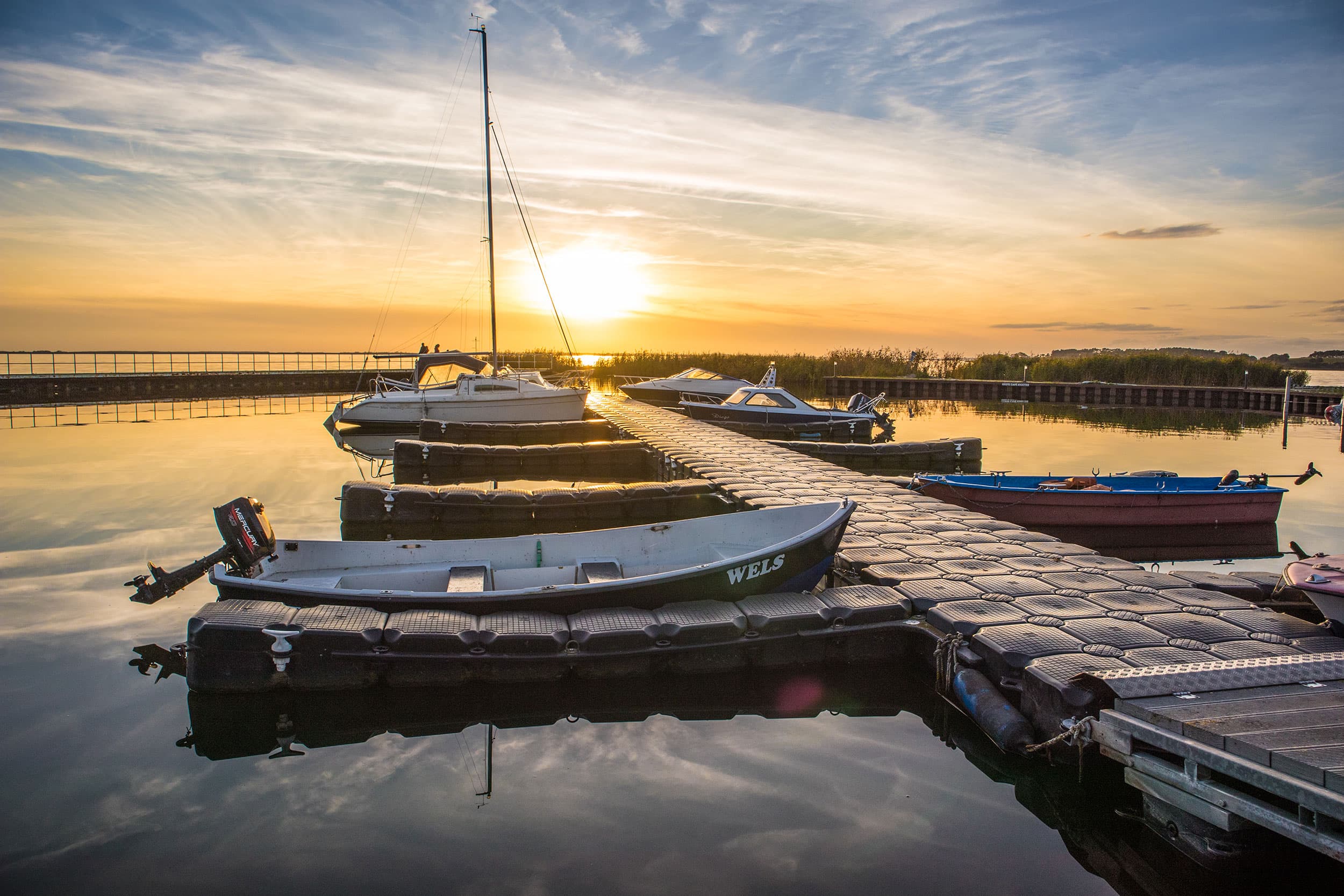 Der Yachthafen in Ückeritz liegt still in der Abenddämmerung zum Sonnenuntergang.
