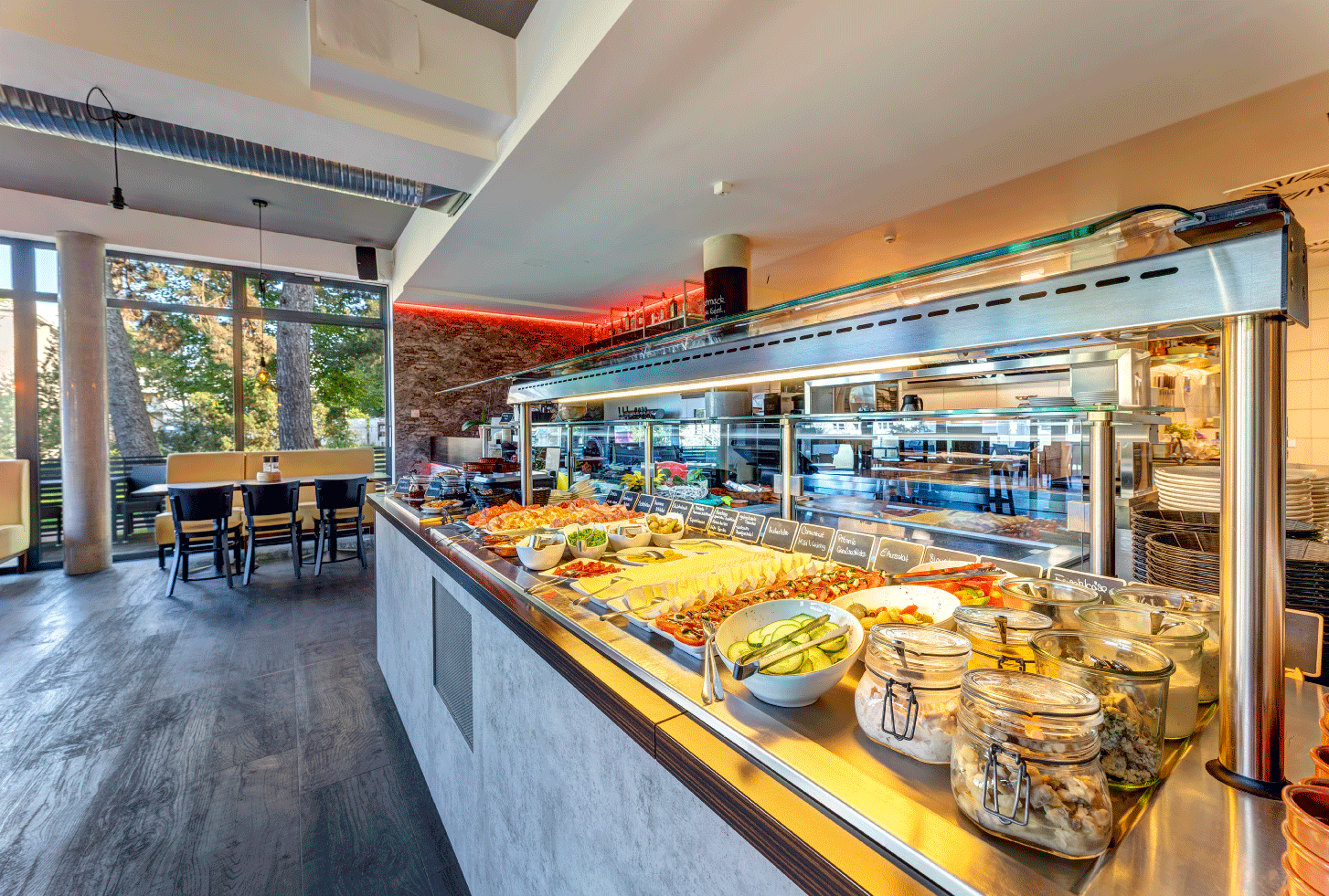 Essbereich mit sehr gut ausgeleuchtetem Buffet, welches sehr bunt und vielfältig angerichtet ist