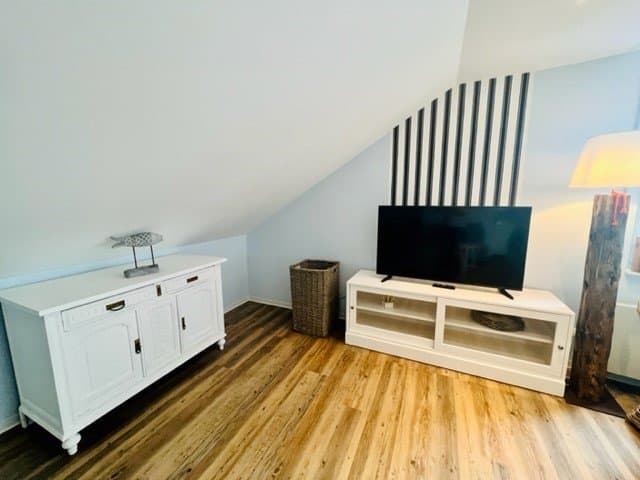 Wohnzimmer mit Holzboden und Fernseher