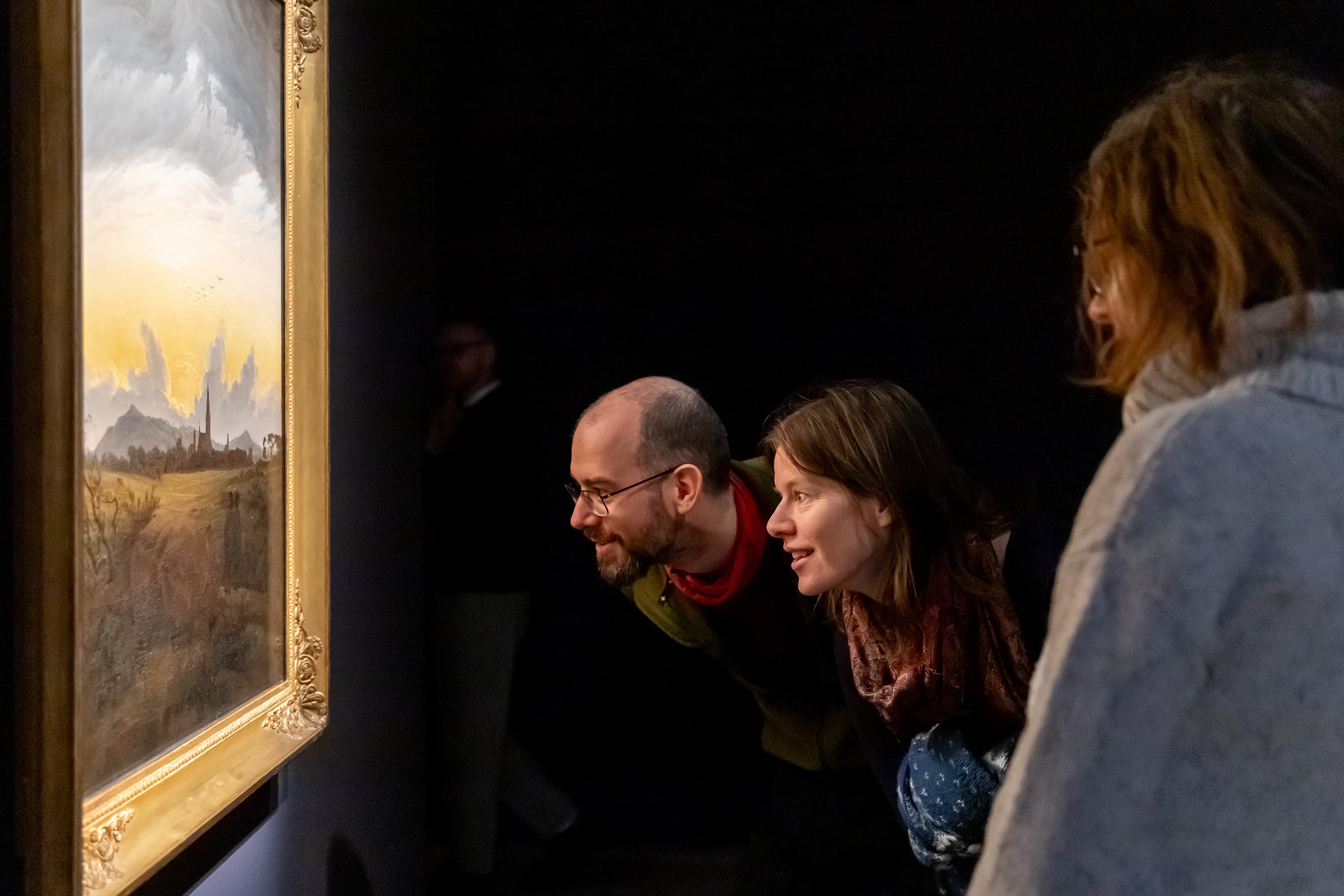 drei Besucher betrachten ein Bild der Malers Caspar David Friedrich